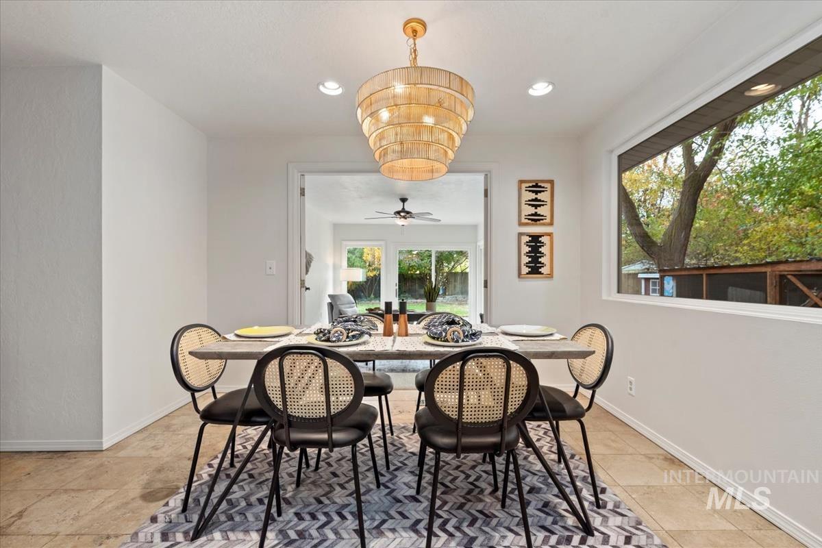 Dining space with recessed lighting, a ceiling fan, and a chandelier