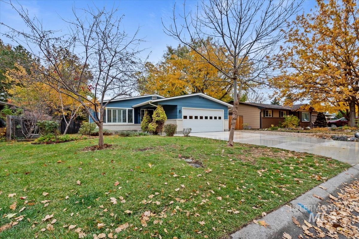 Single story home with concrete driveway, a front lawn, and a garage