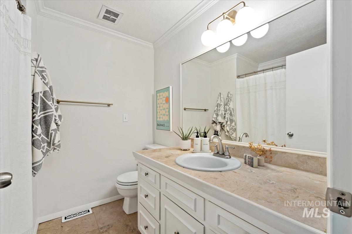 Full bath with crown molding, vanity, a shower with curtain, and light tile patterned floors