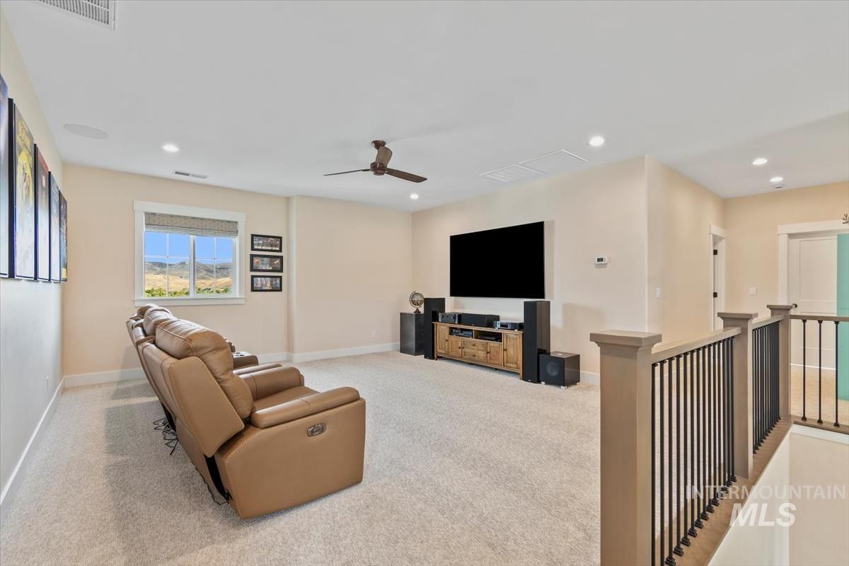 Living area with carpet, recessed lighting, and ceiling fan
