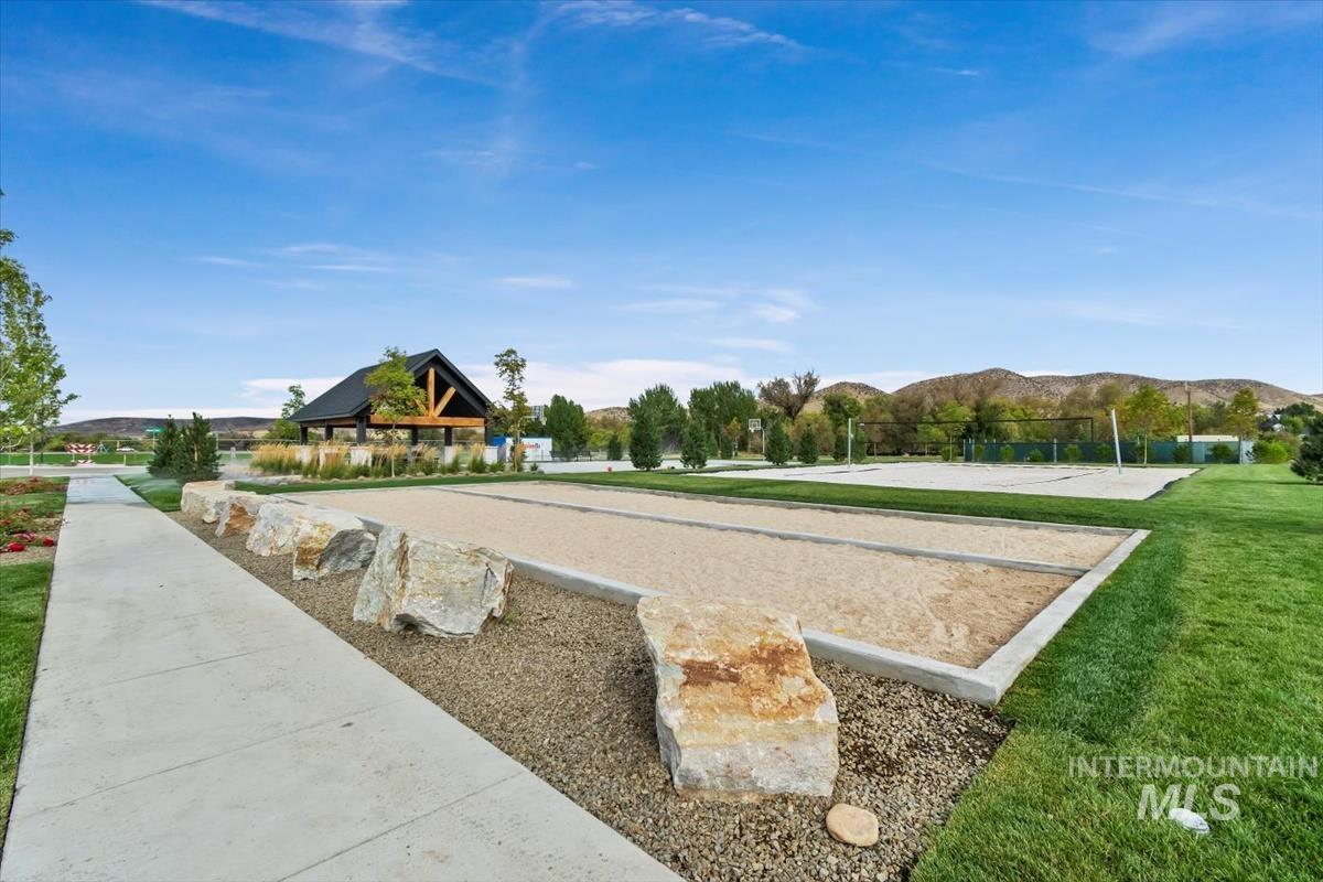 View of community with a bocce ball area, a mountain view, and a yard