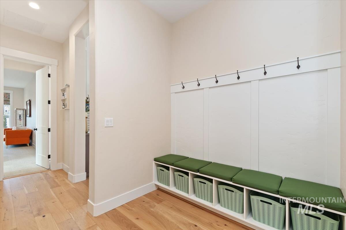 Mudroom featuring light wood-style flooring and baseboards