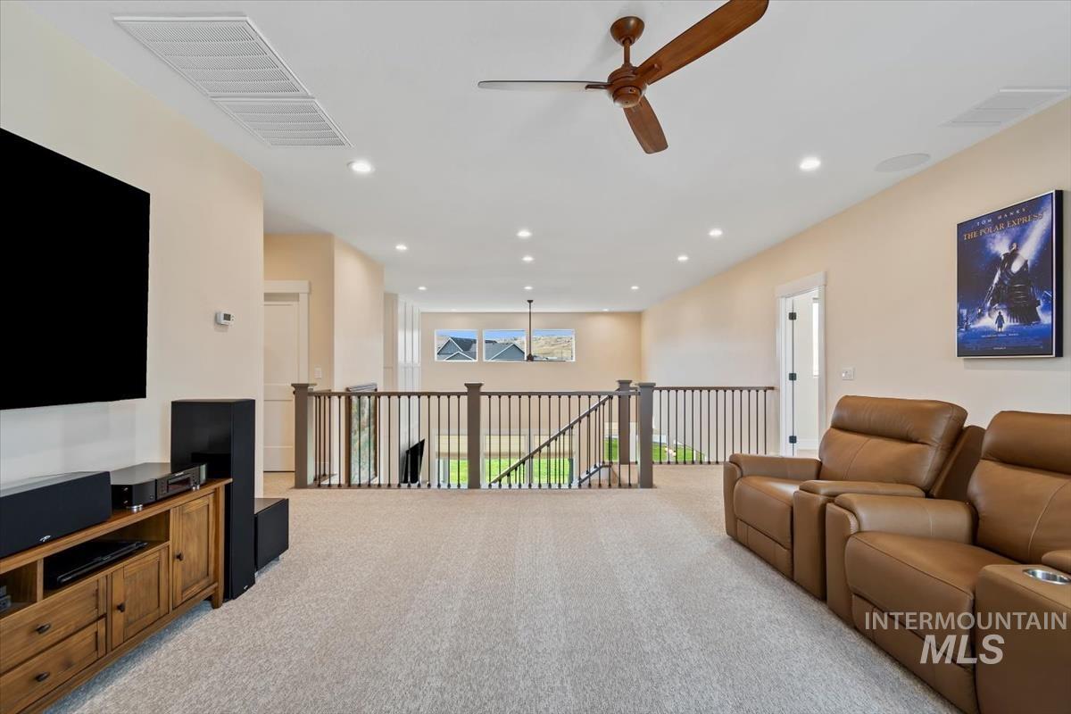 Living area with recessed lighting, light colored carpet, and a ceiling fan