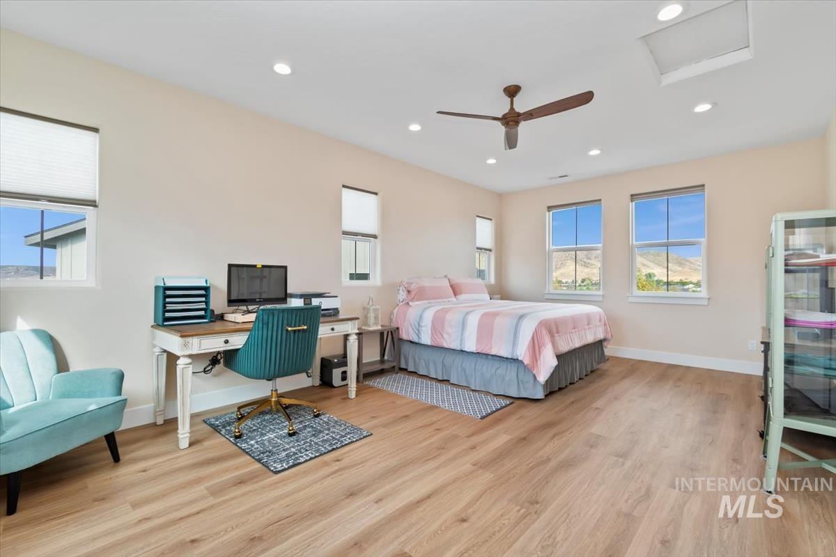 Bedroom featuring an office area, recessed lighting, light wood-type flooring, ceiling fan, and attic access