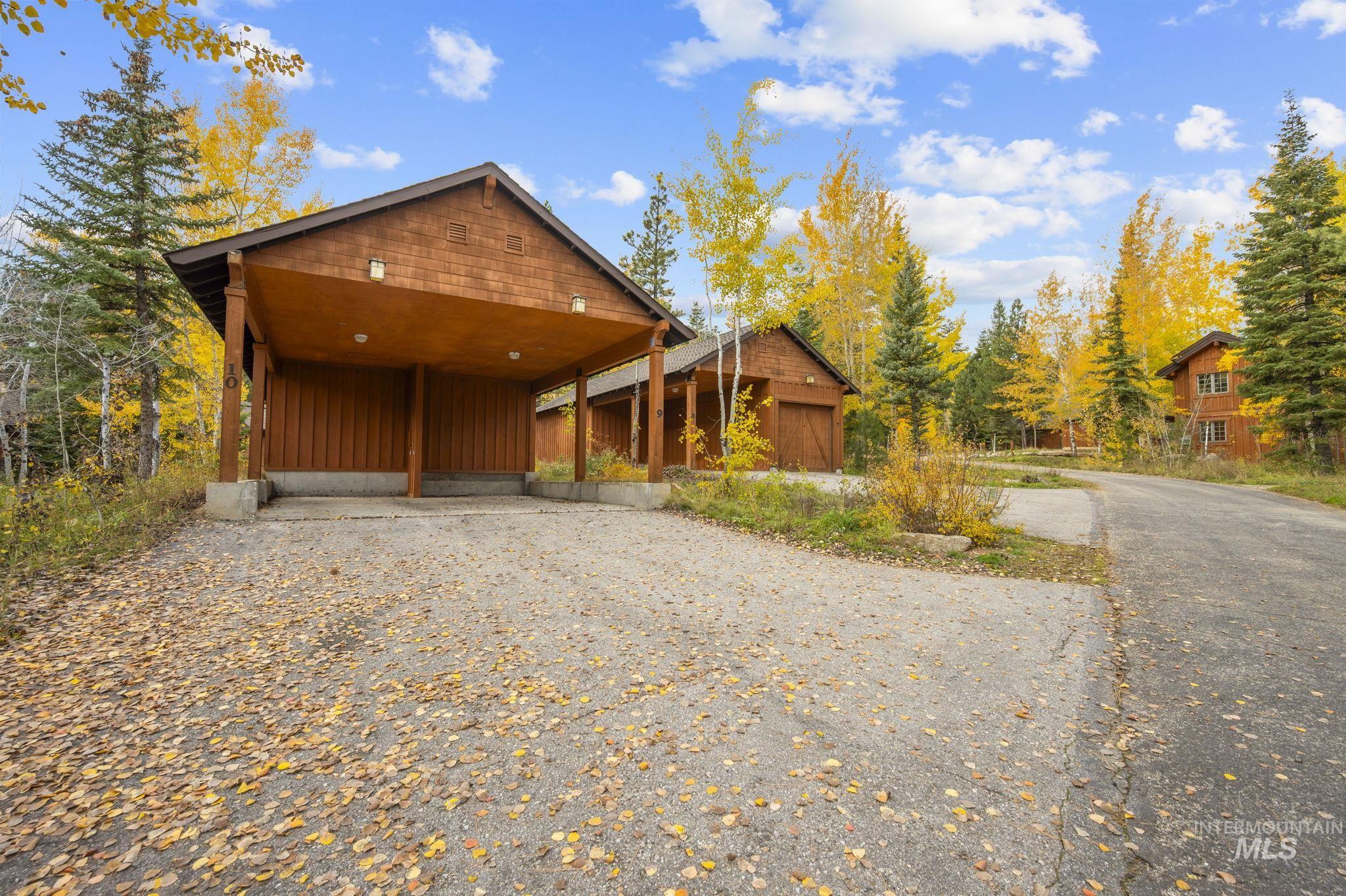 View of front facade with board and batten siding, a carport, and driveway