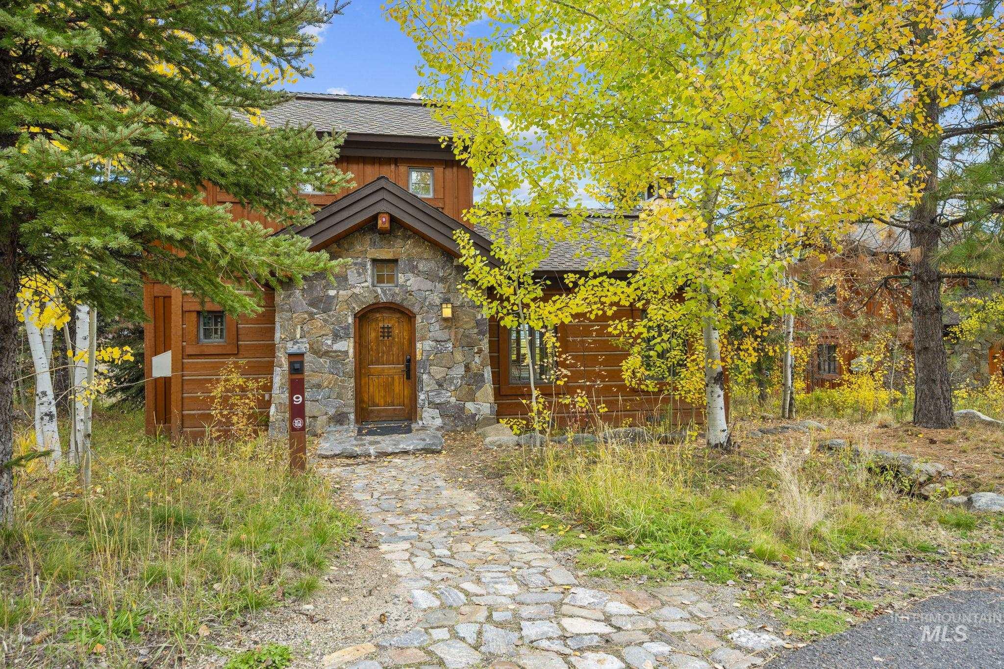 Chalet / cabin featuring stone siding and a shingled roof