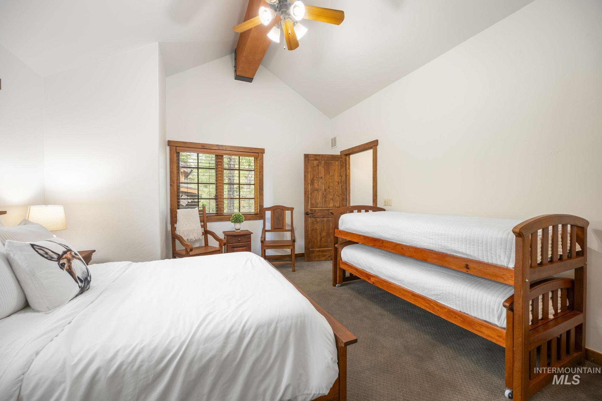 Bedroom featuring beamed ceiling, carpet floors, high vaulted ceiling, and a ceiling fan