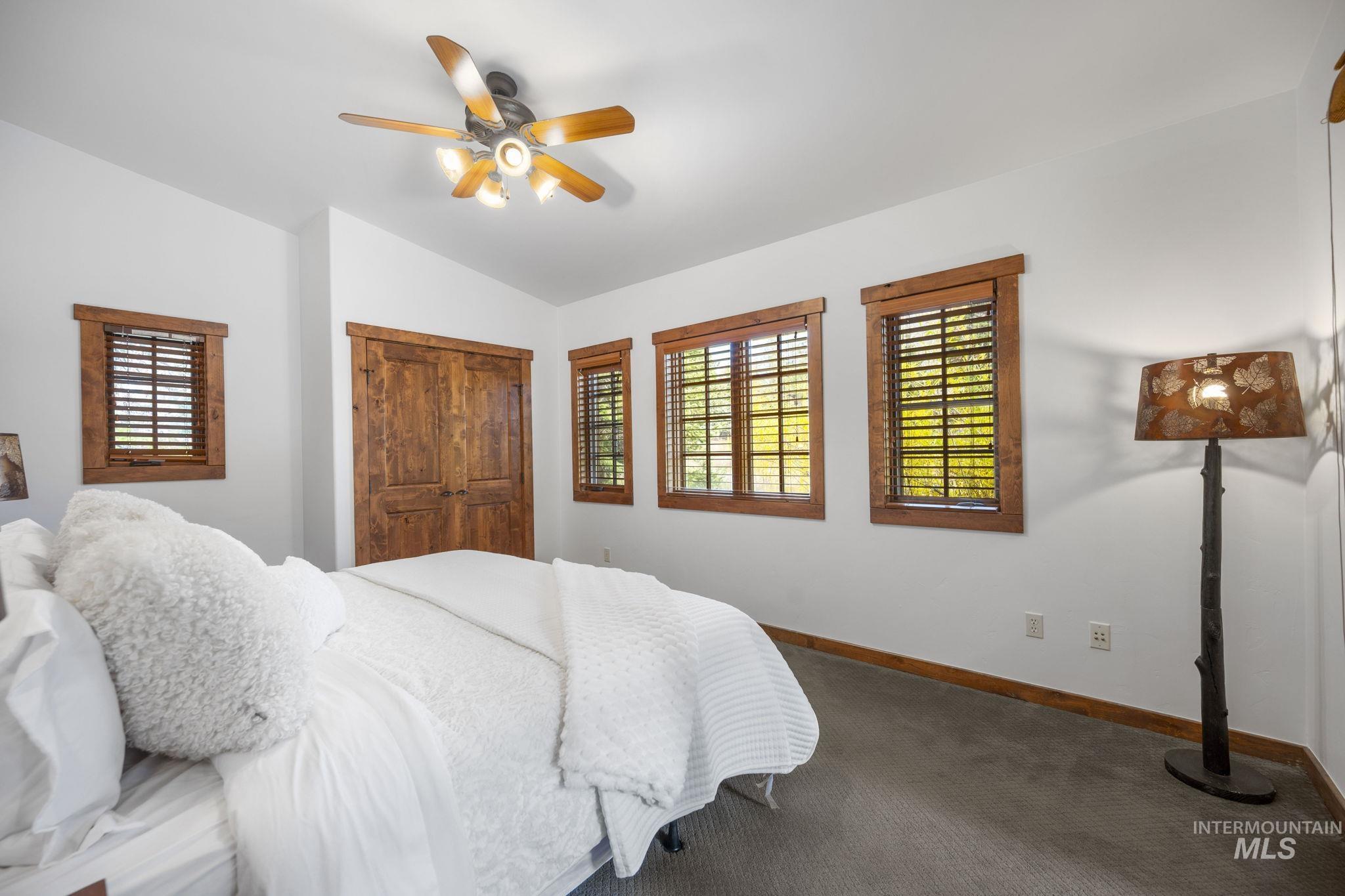 Bedroom with a closet, vaulted ceiling, a ceiling fan, and carpet flooring