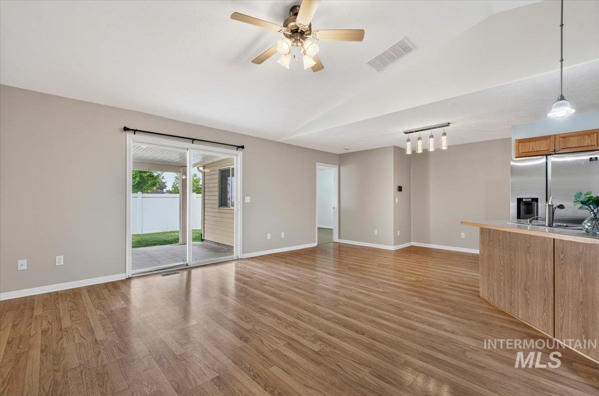 Spacious interior featuring wood-finish flooring, neutral wall tones, and vaulted ceilings