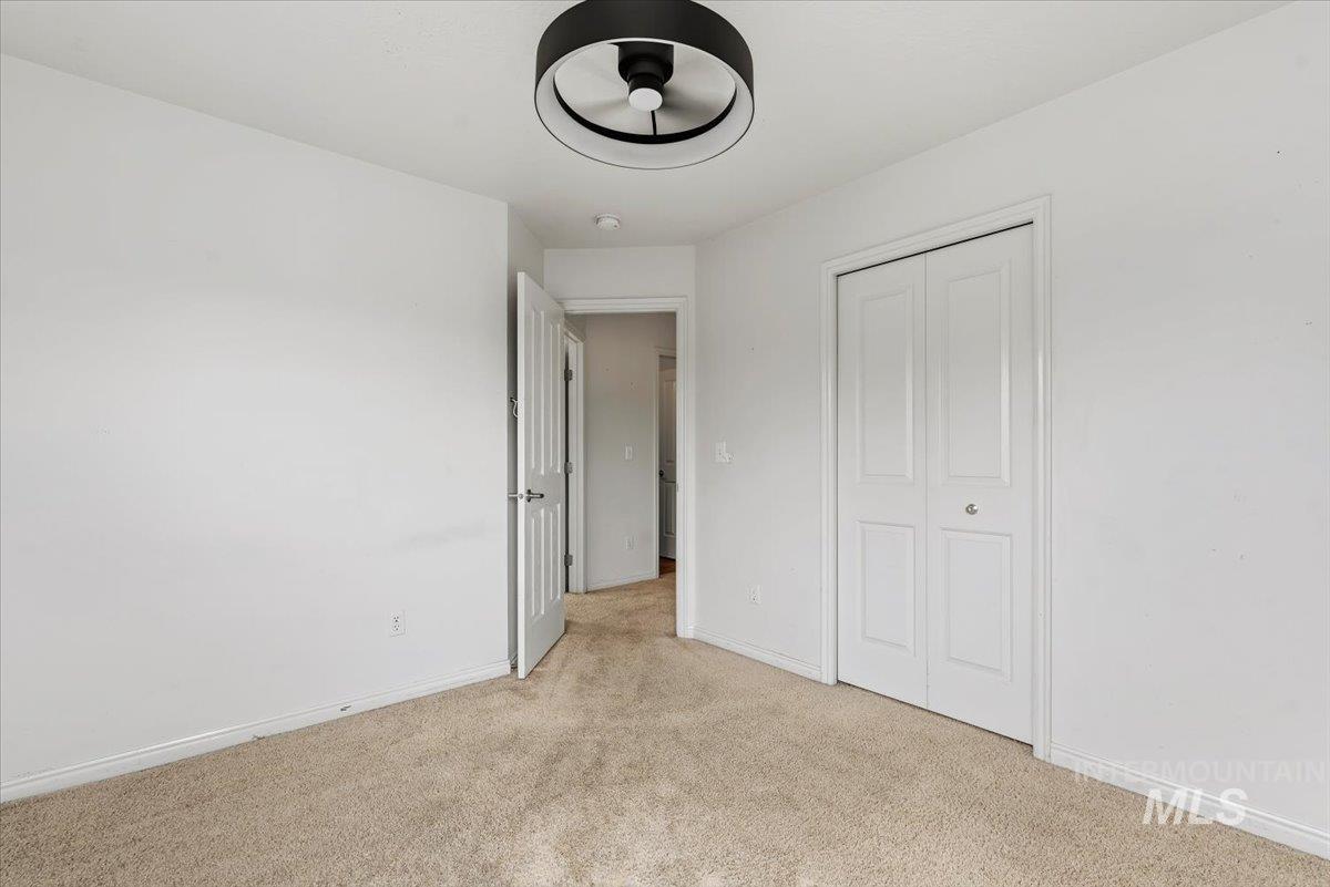 Carpeted room featuring a modern ceiling fixture, white walls, and white trim