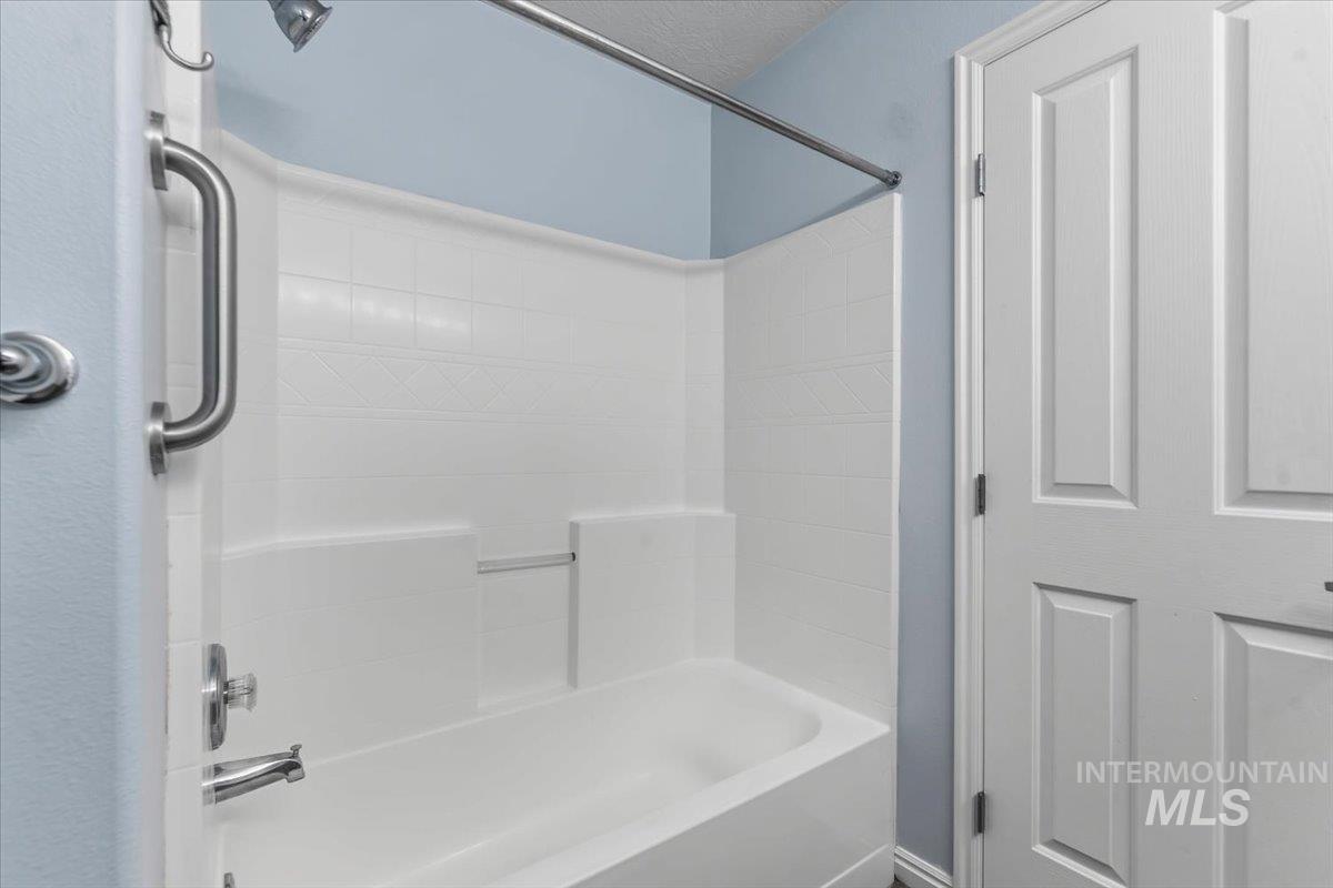 White tub and shower combination with chrome fixtures