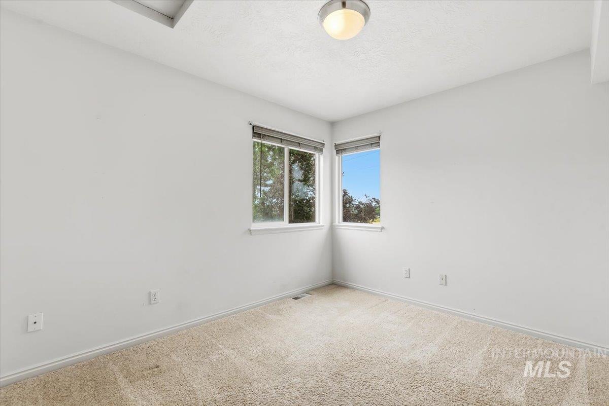 Interior room featuring light-colored carpeting, white painted walls, and white trim
