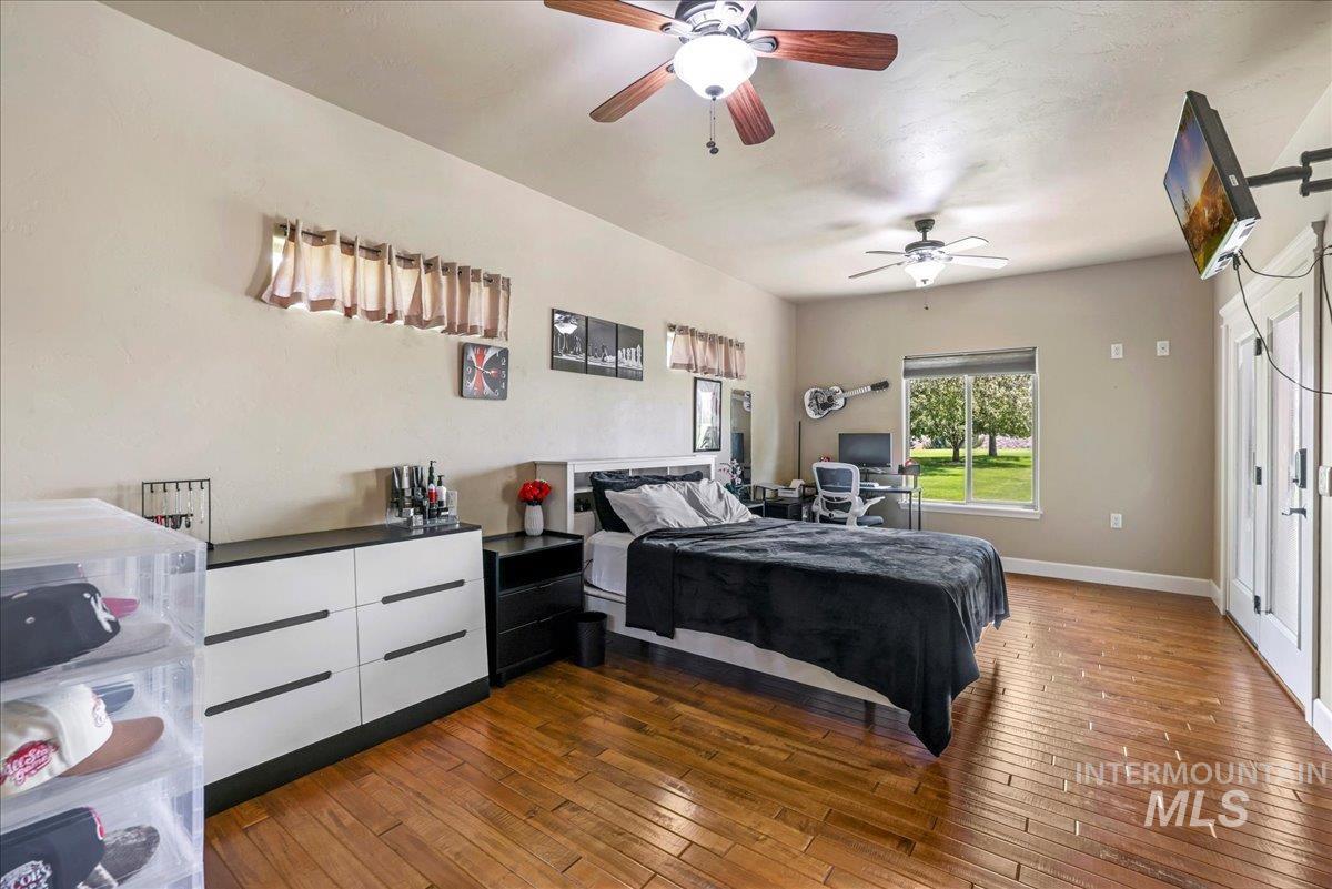 Bedroom with hardwood / wood-style floors and a ceiling fan