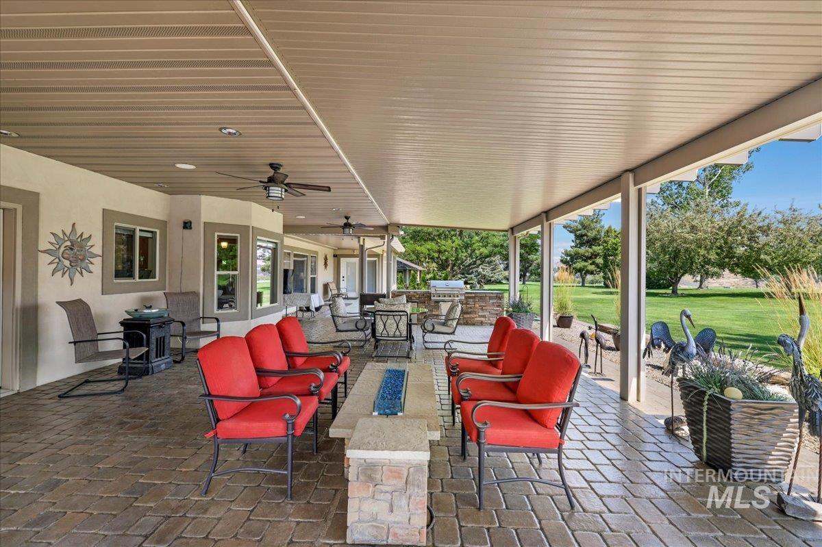 View of patio with an outdoor living space, ceiling fan, grilling area, and outdoor dining space