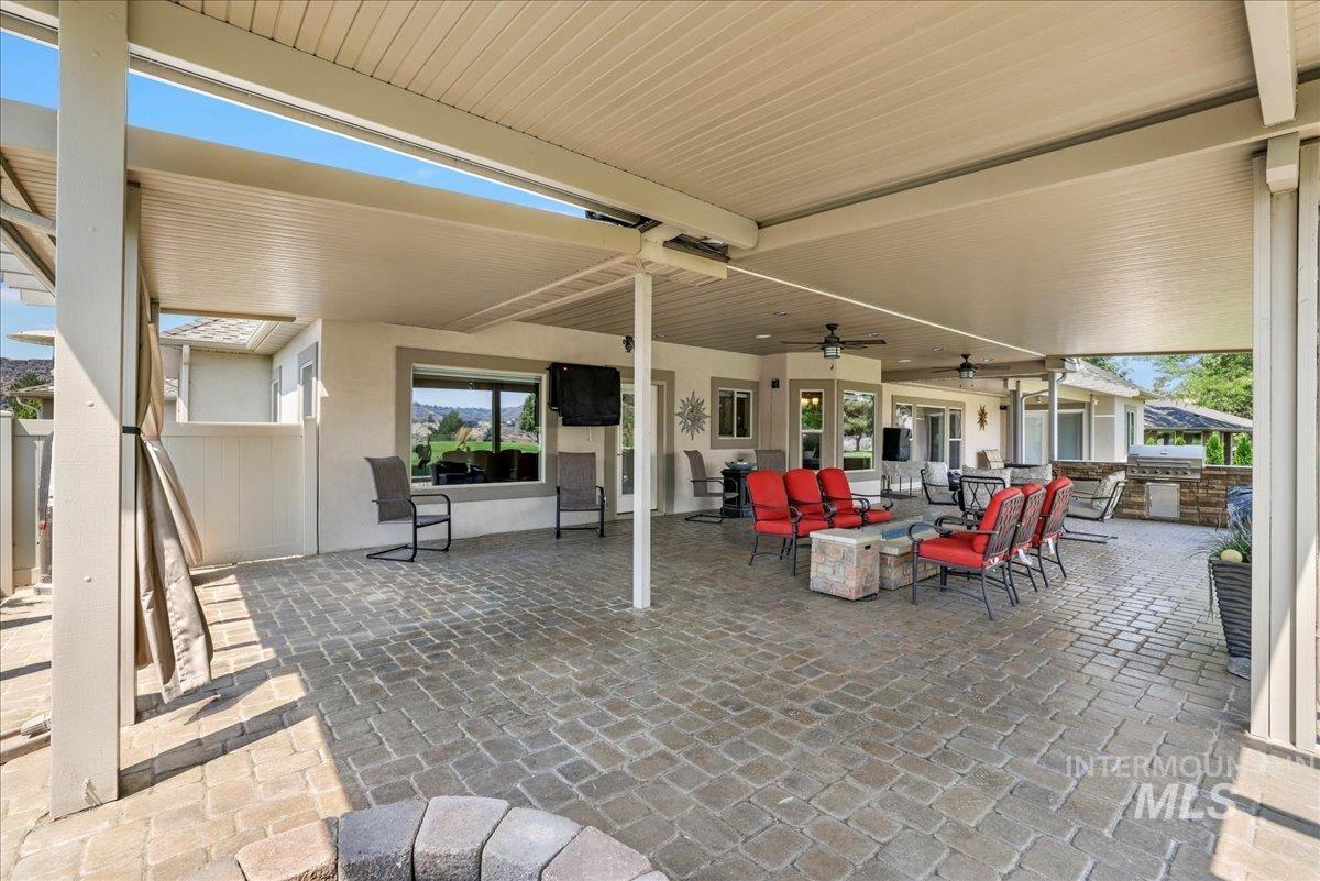 View of patio with a ceiling fan, an outdoor living space, and an outdoor kitchen