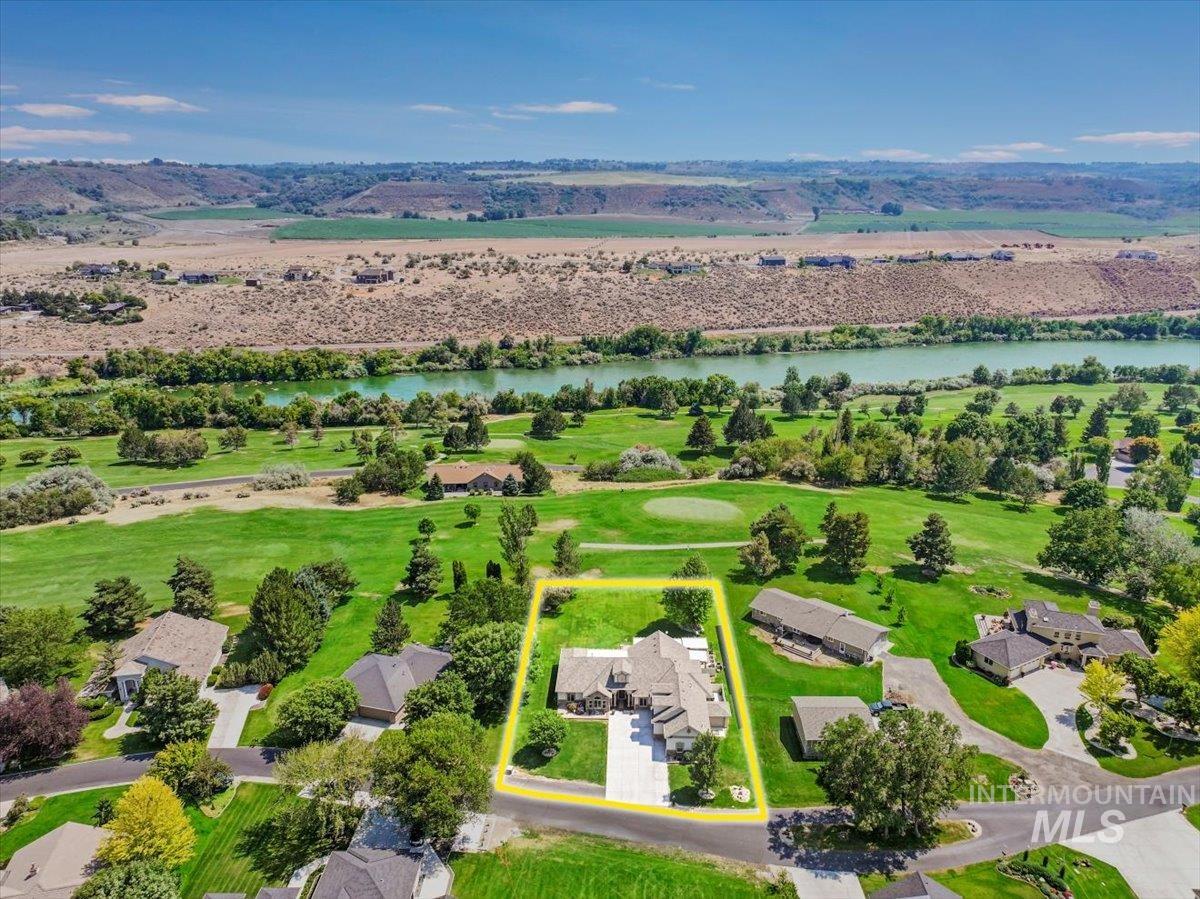 Aerial view of residential area with a nearby body of water and property boundaries highlighted
