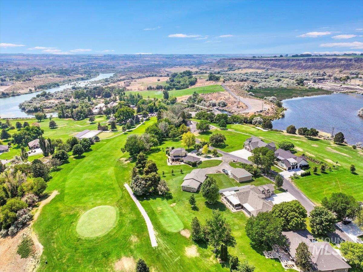 Aerial view of residential area with a nearby body of water and a local golf course