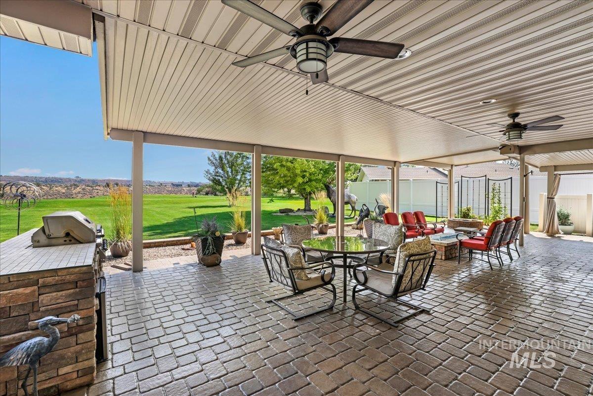 View of patio featuring a ceiling fan, outdoor dining space, an outdoor hangout area, and an outdoor kitchen