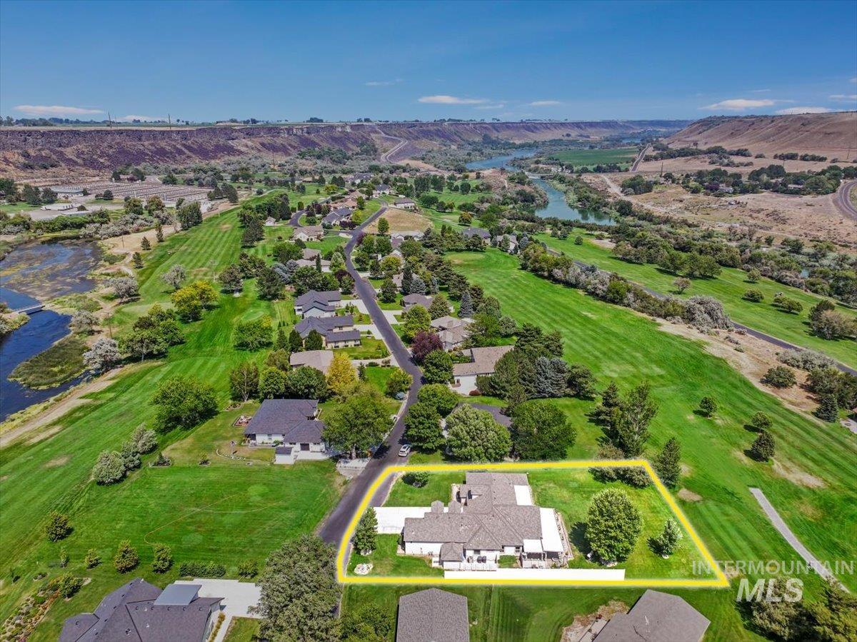 Aerial perspective of suburban area featuring property boundaries highlighted and a water and mountain view