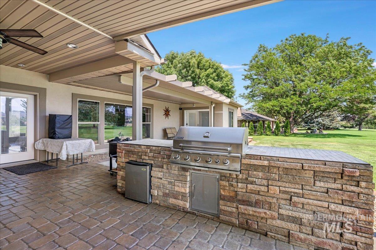 View of patio / terrace featuring area for grilling and a ceiling fan