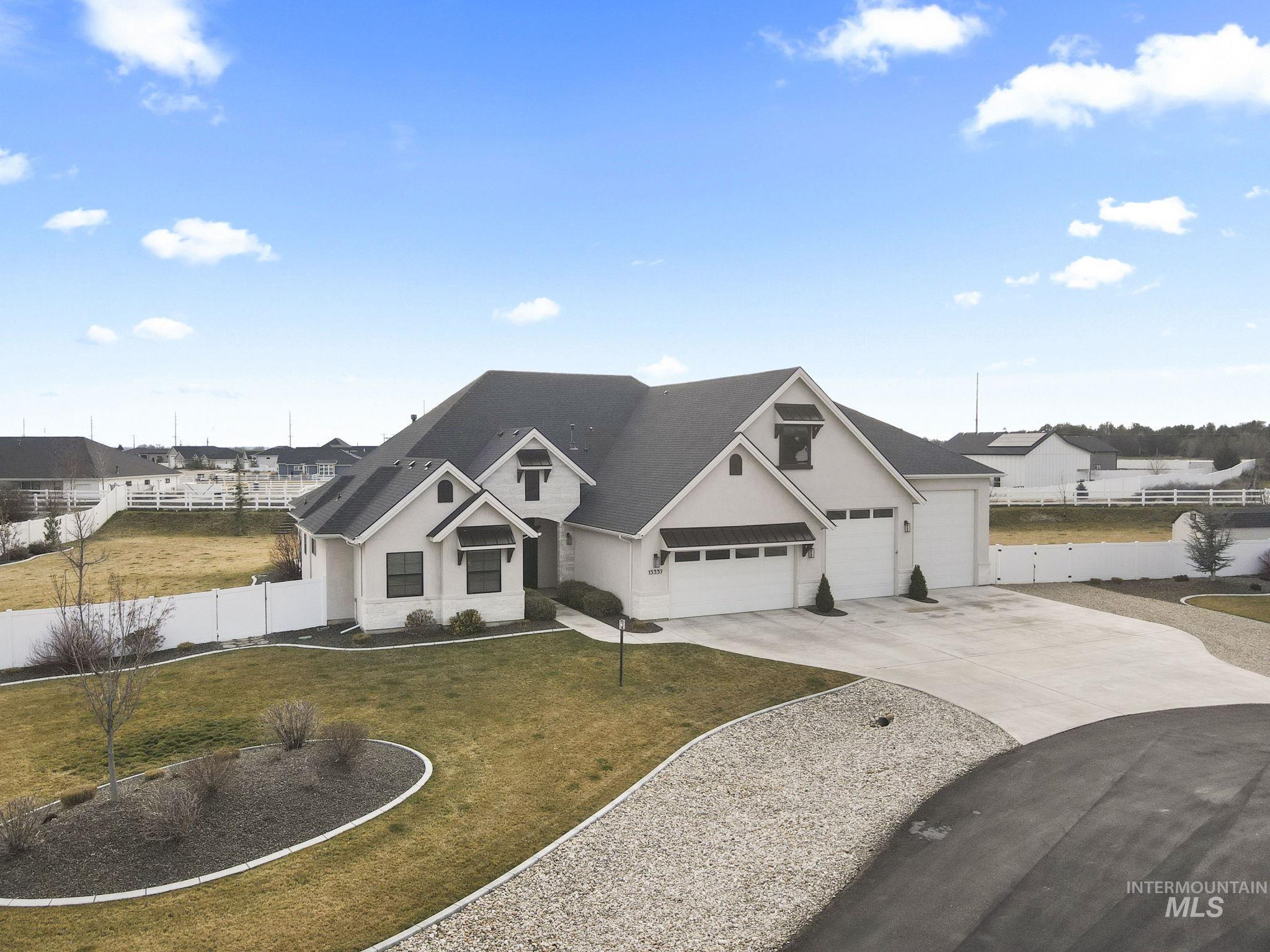 Modern inspired farmhouse with concrete driveway, stucco siding, and an attached garage
