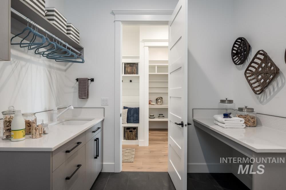 Bathroom featuring vanity, a walk in closet, and dark tile patterned floors