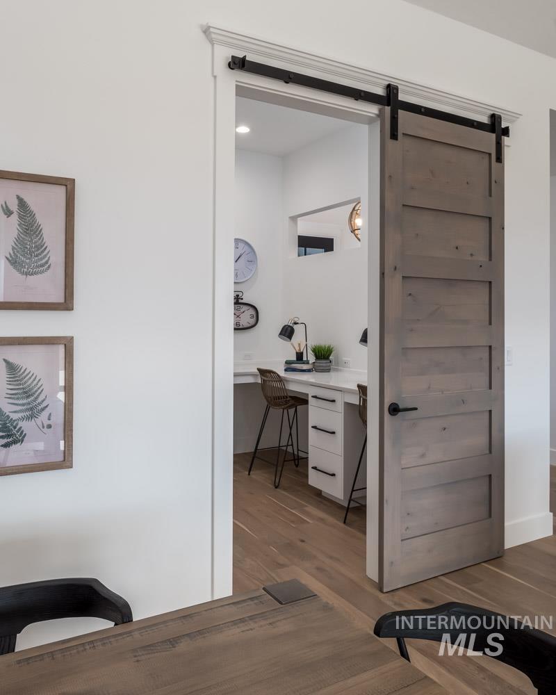 Tech room with dark wood finished floors, and a barn door