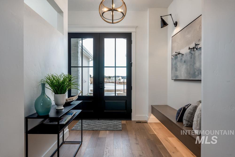Entryway with hardwood / wood-style floors, a chandelier, and french doors