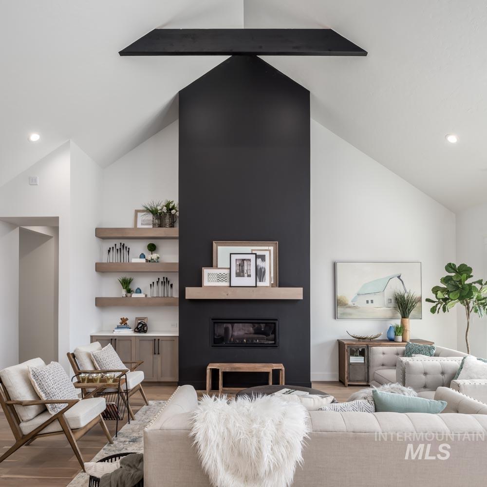 Living area with recessed lighting, wood finished floors, and a glass covered fireplace