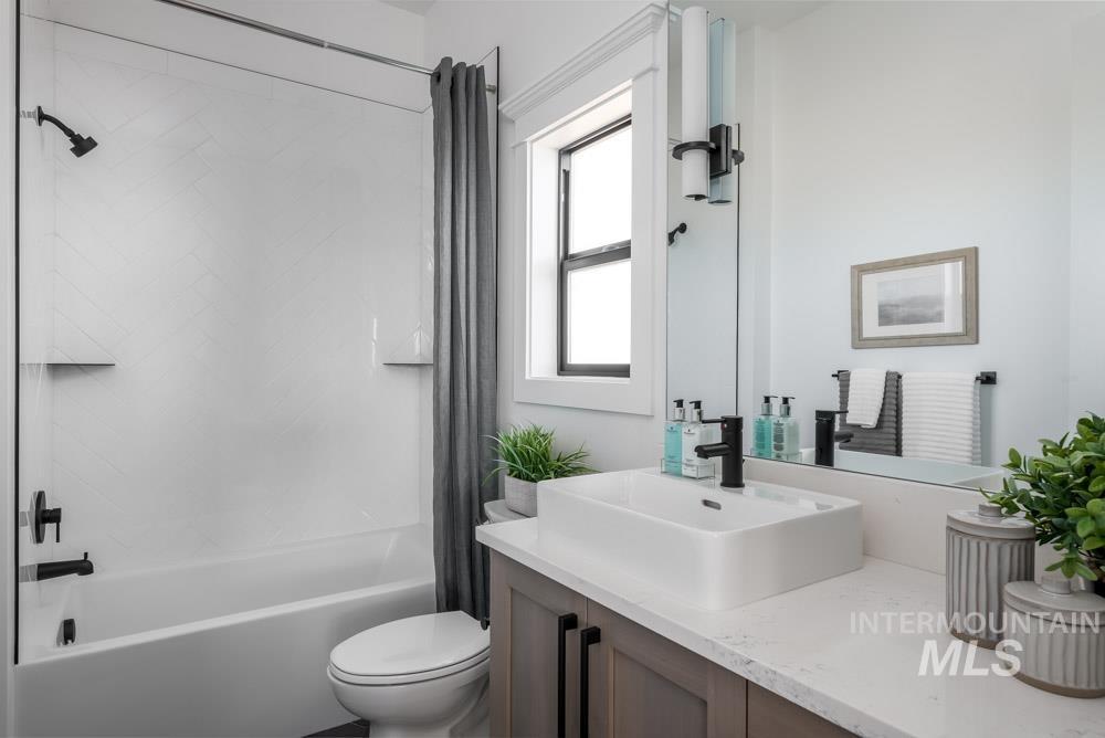 Bathroom featuring shower / bathtub combination with curtain and vanity