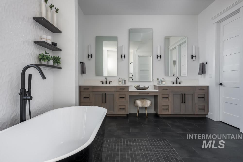 Bathroom with double vanity, a soaking tub, and dark tile patterned flooring