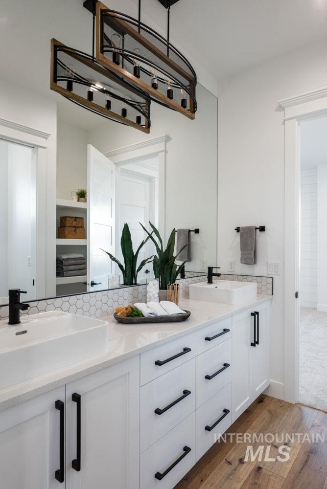 Kitchen with white cabinetry, light stone counters, and dark wood-type flooring