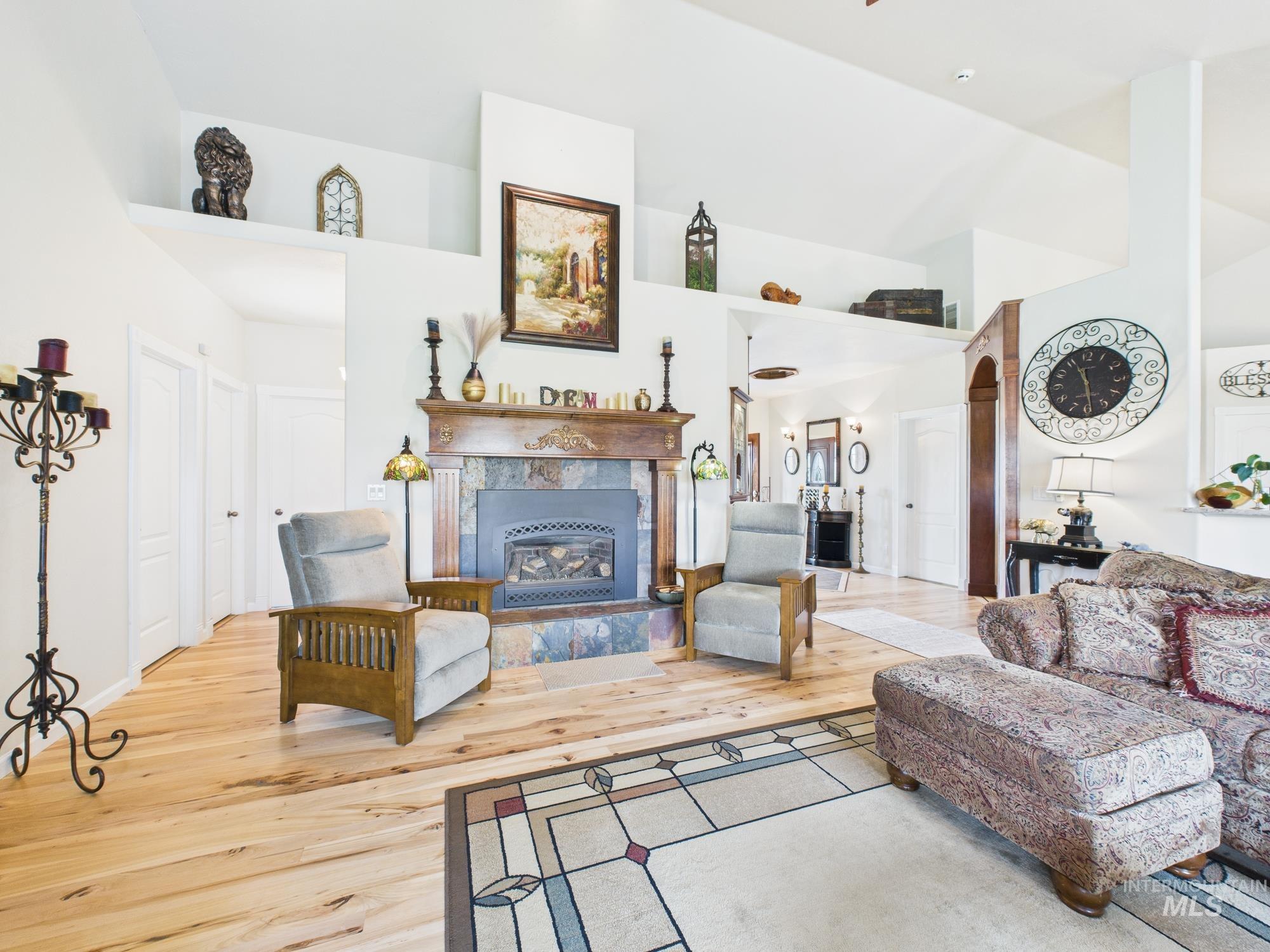 Living area featuring wood finished floors, a towering ceiling, and a premium fireplace