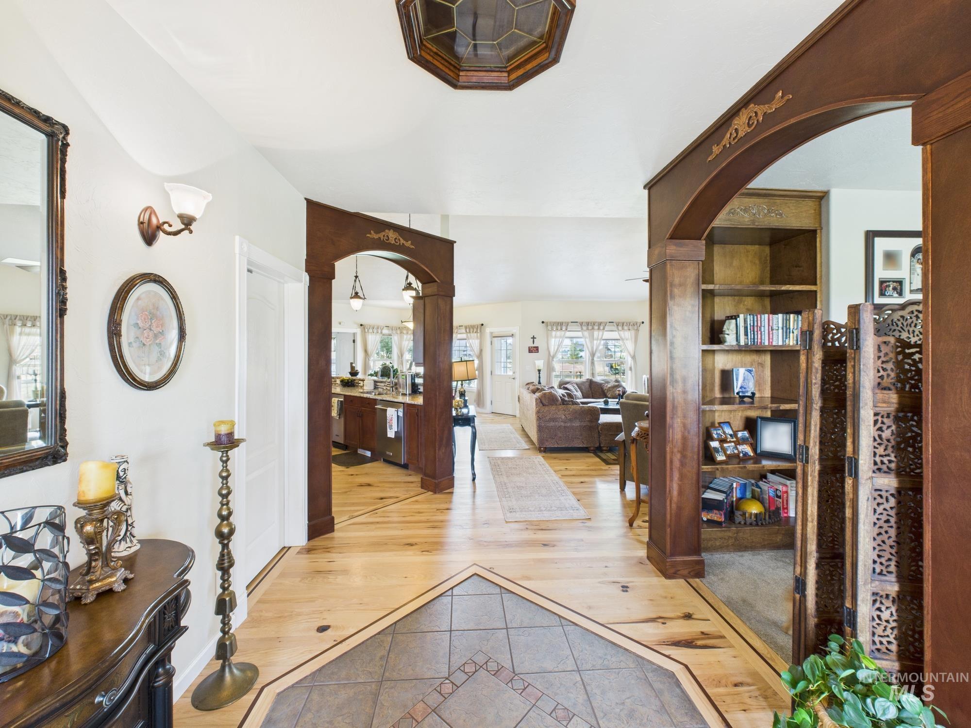 Entrance foyer with inlaid floor details, arched walkways, and light tile patterned floors