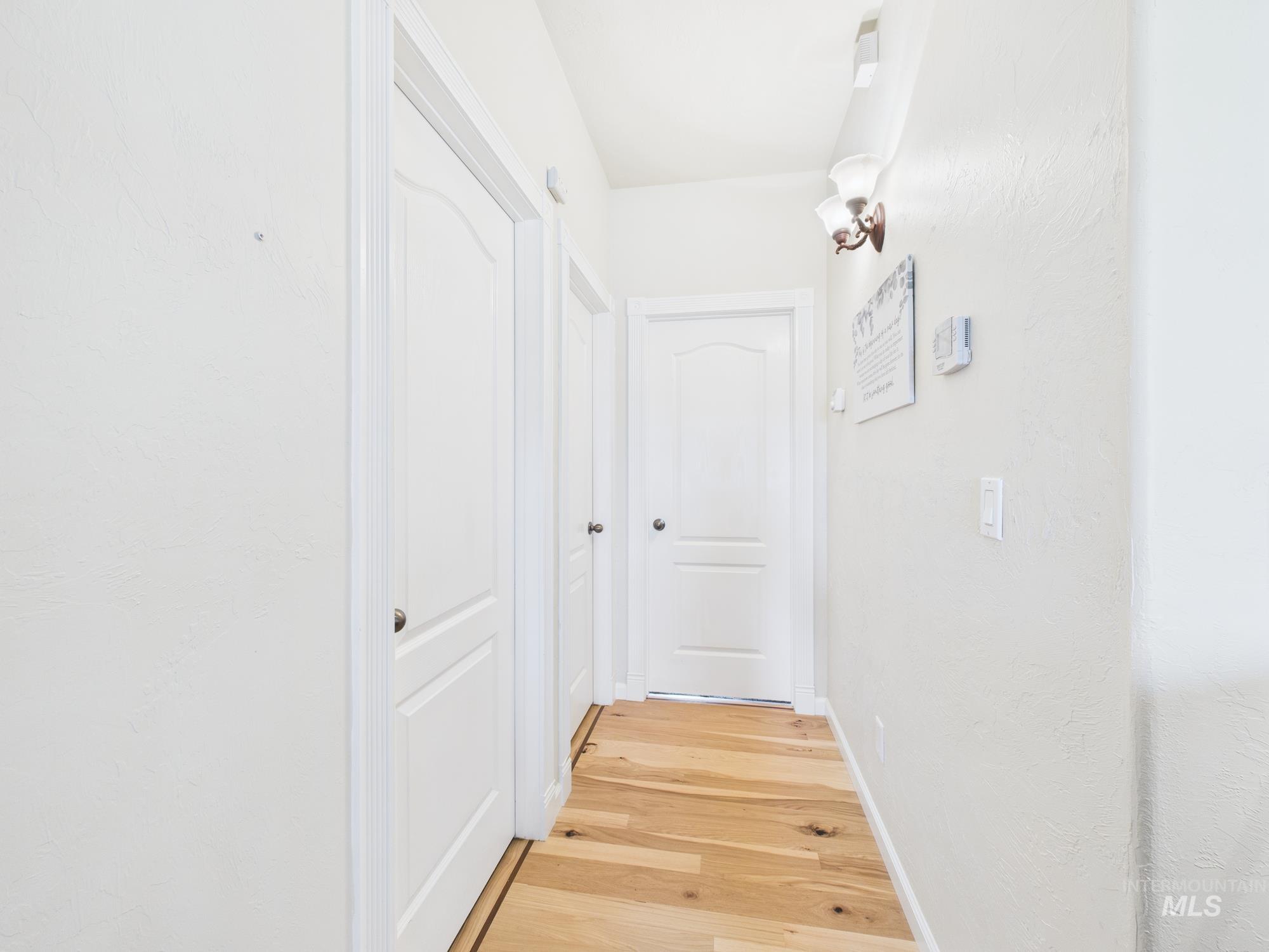 Hall with light wood-style flooring and baseboards
