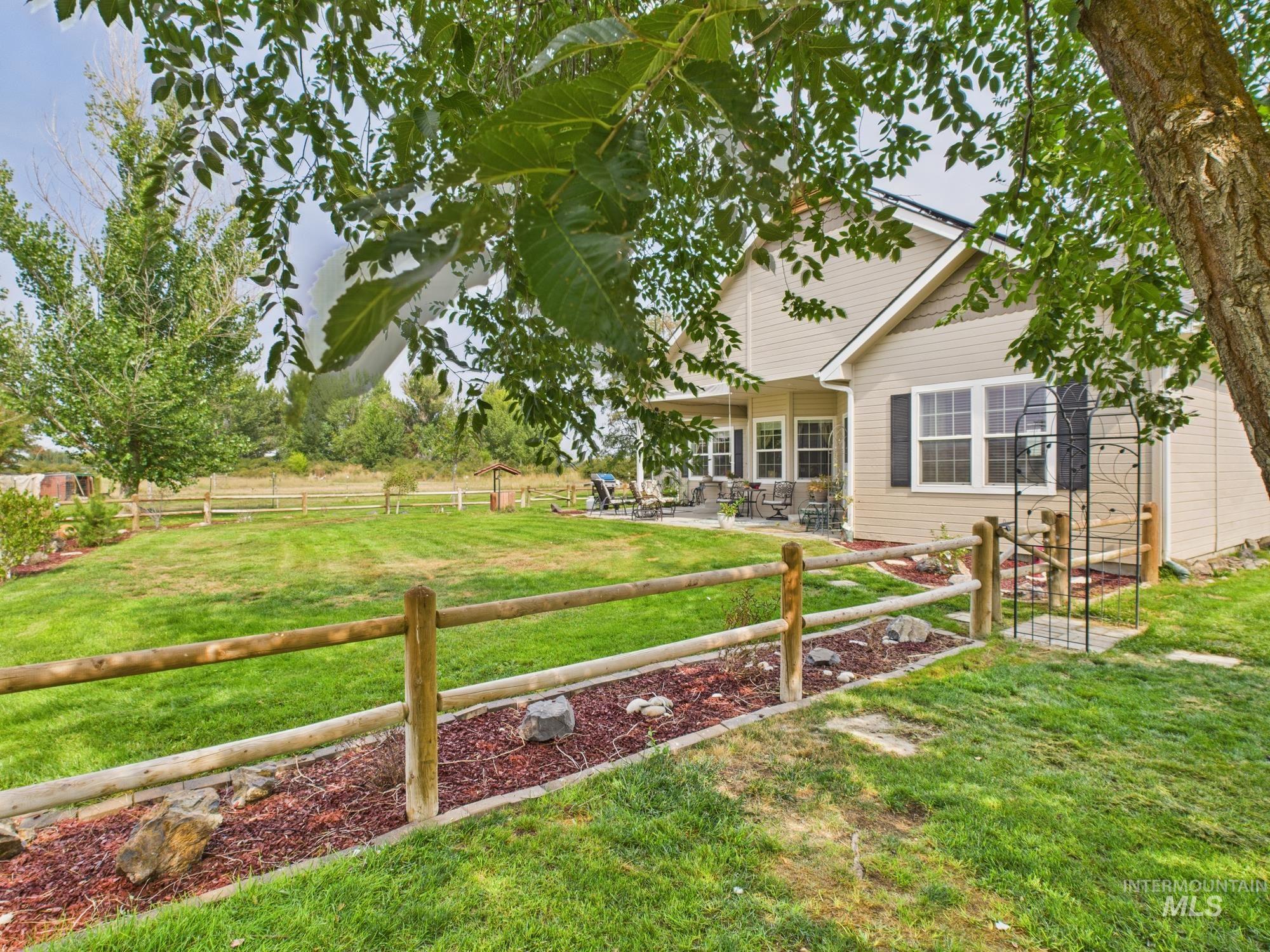 Fenced backyard with a patio and a view of rural / pastoral area