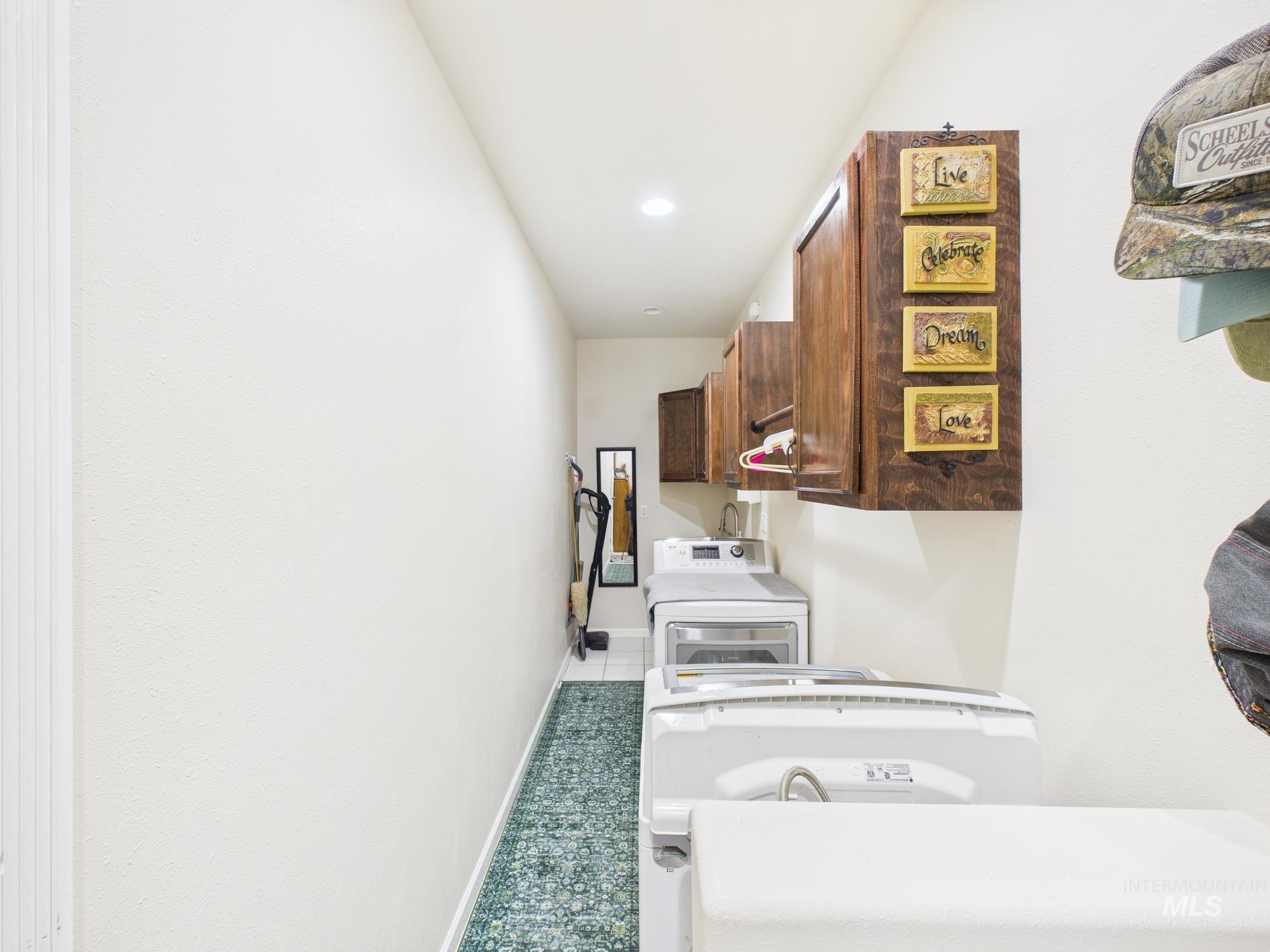 Laundry room featuring cabinet space, separate washer and dryer, recessed lighting, and tile patterned flooring