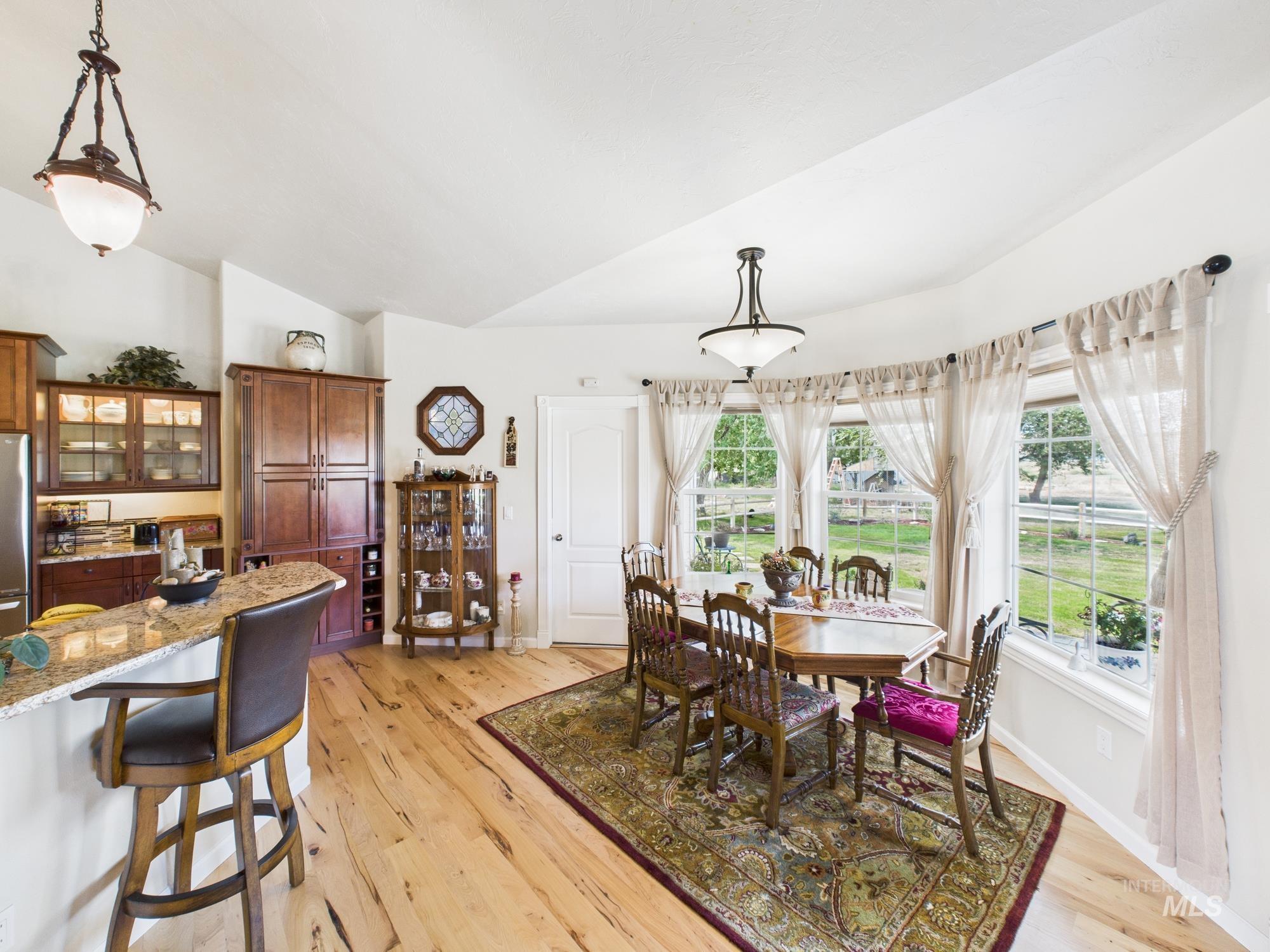 Dining room featuring light wood finished floors and vaulted ceiling