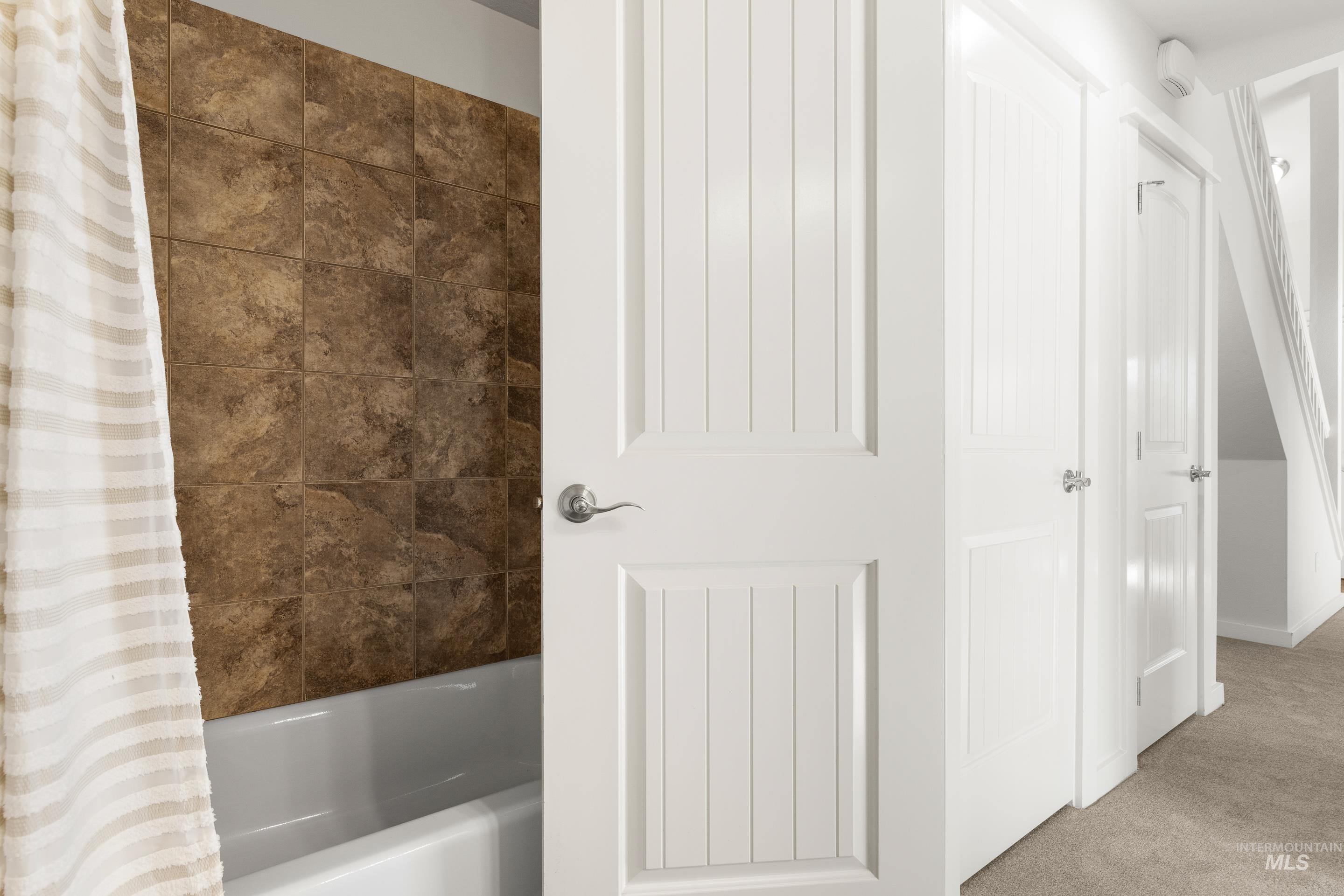 Bathroom featuring shower / bath combination with curtain and carpet