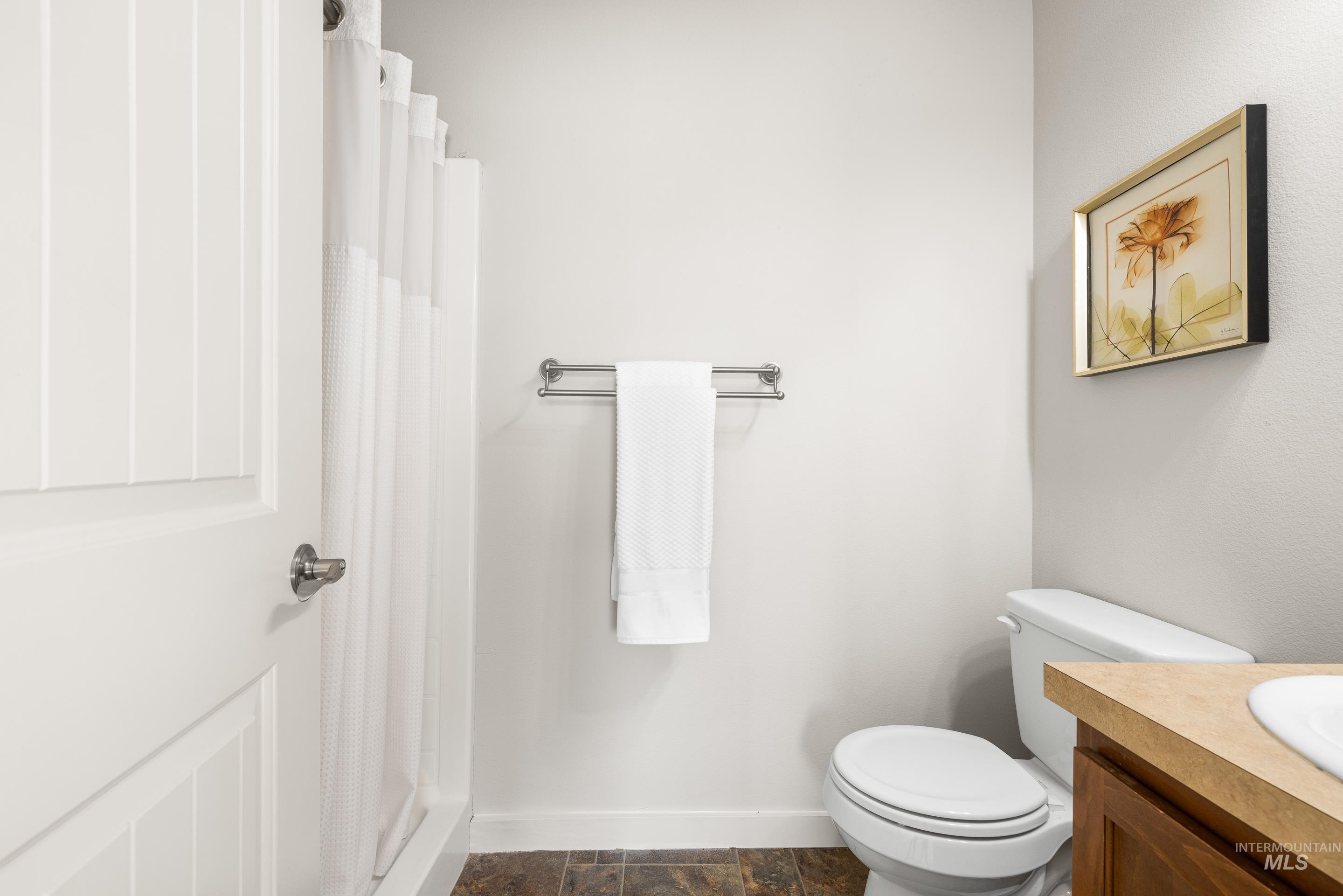 Full bath with curtained shower and vanity