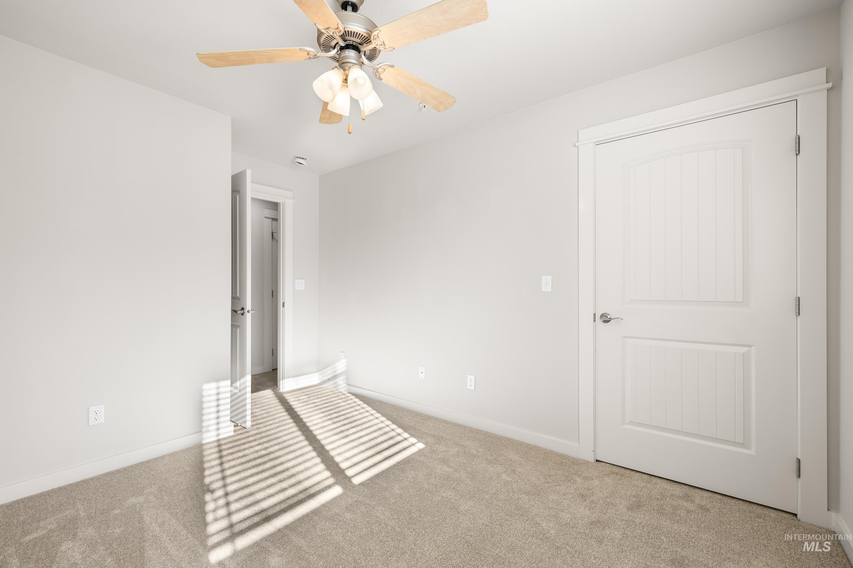 Unfurnished bedroom with carpet flooring and a ceiling fan