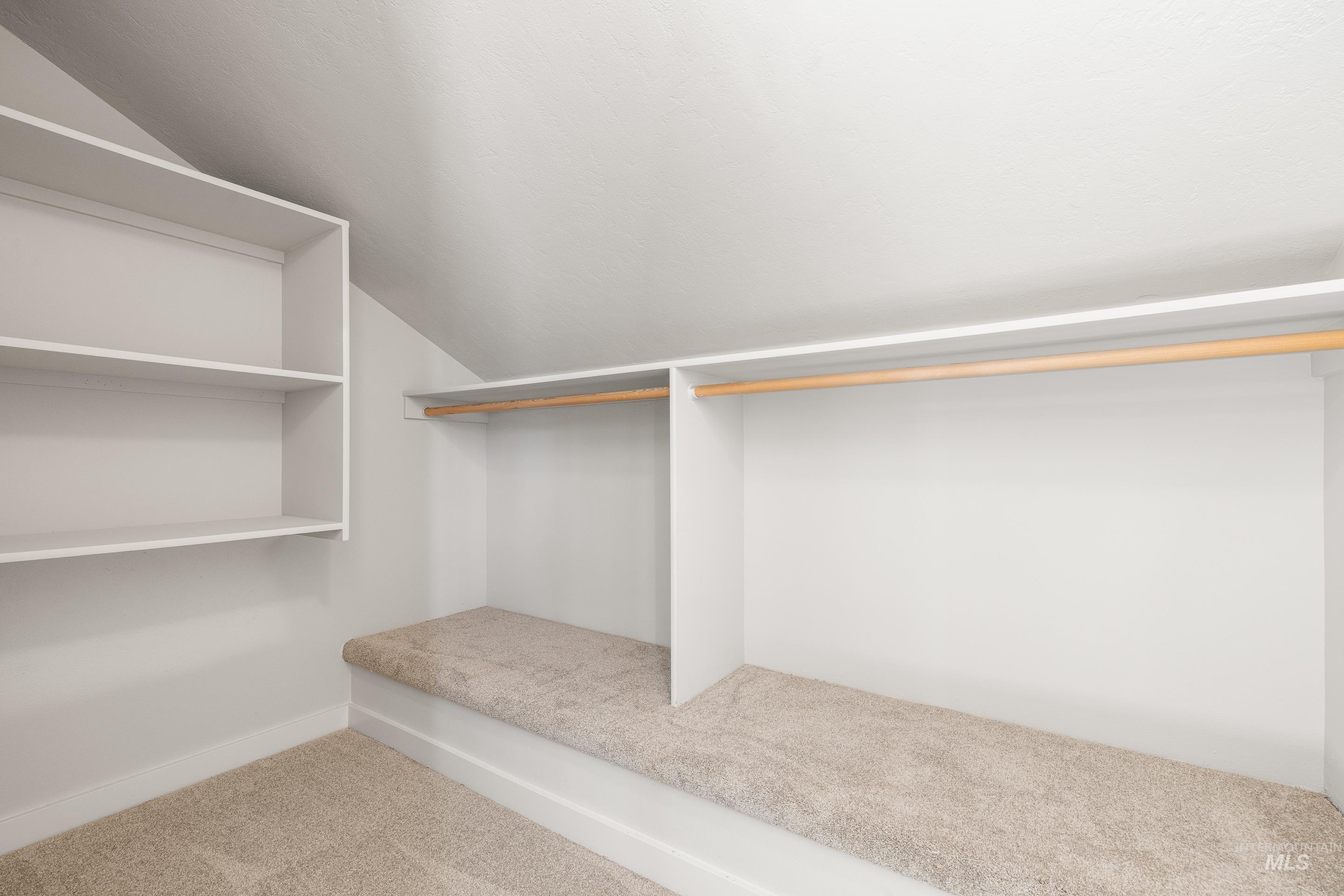 Walk in closet featuring carpet flooring and lofted ceiling