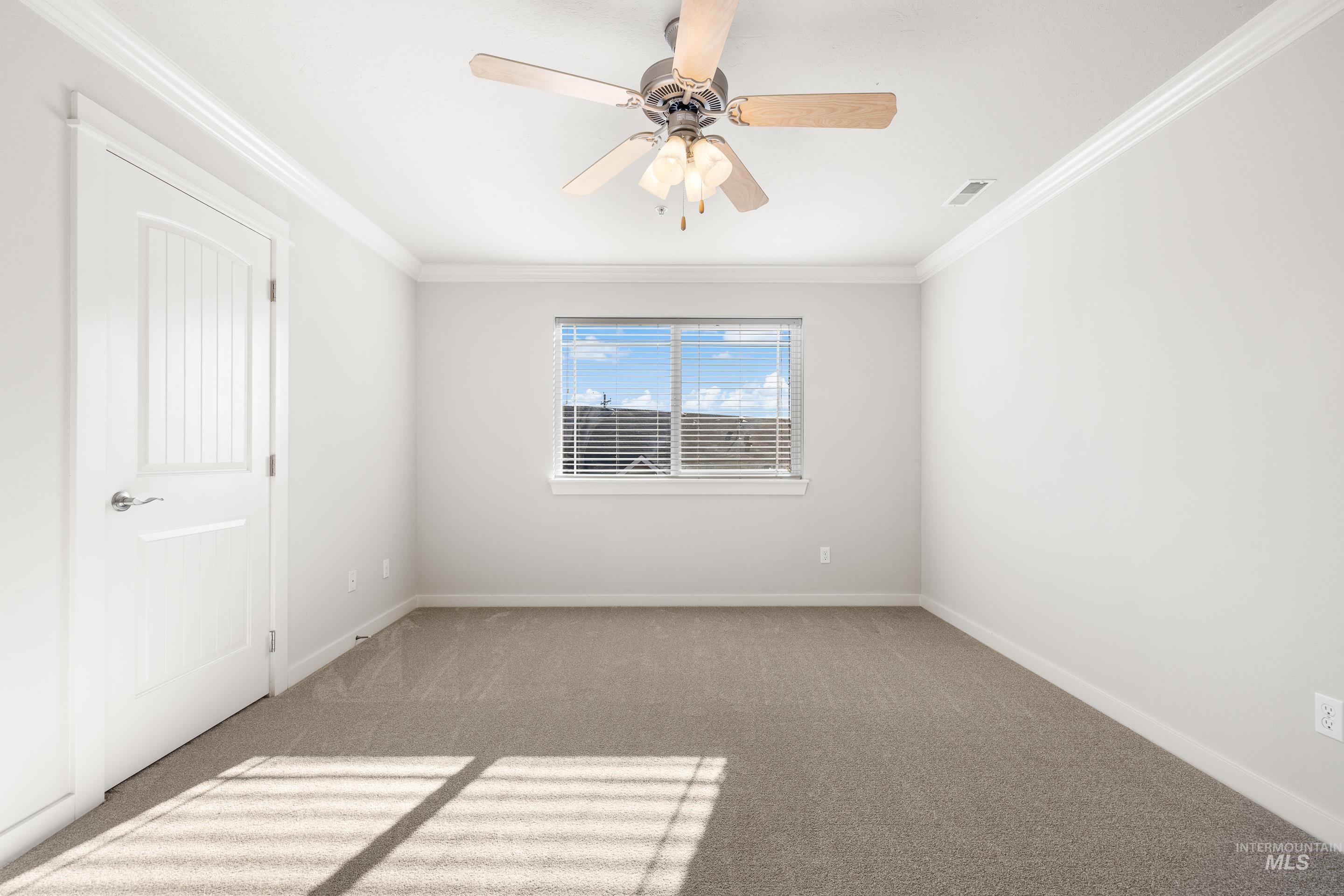 Unfurnished room featuring ornamental molding, carpet floors, and ceiling fan