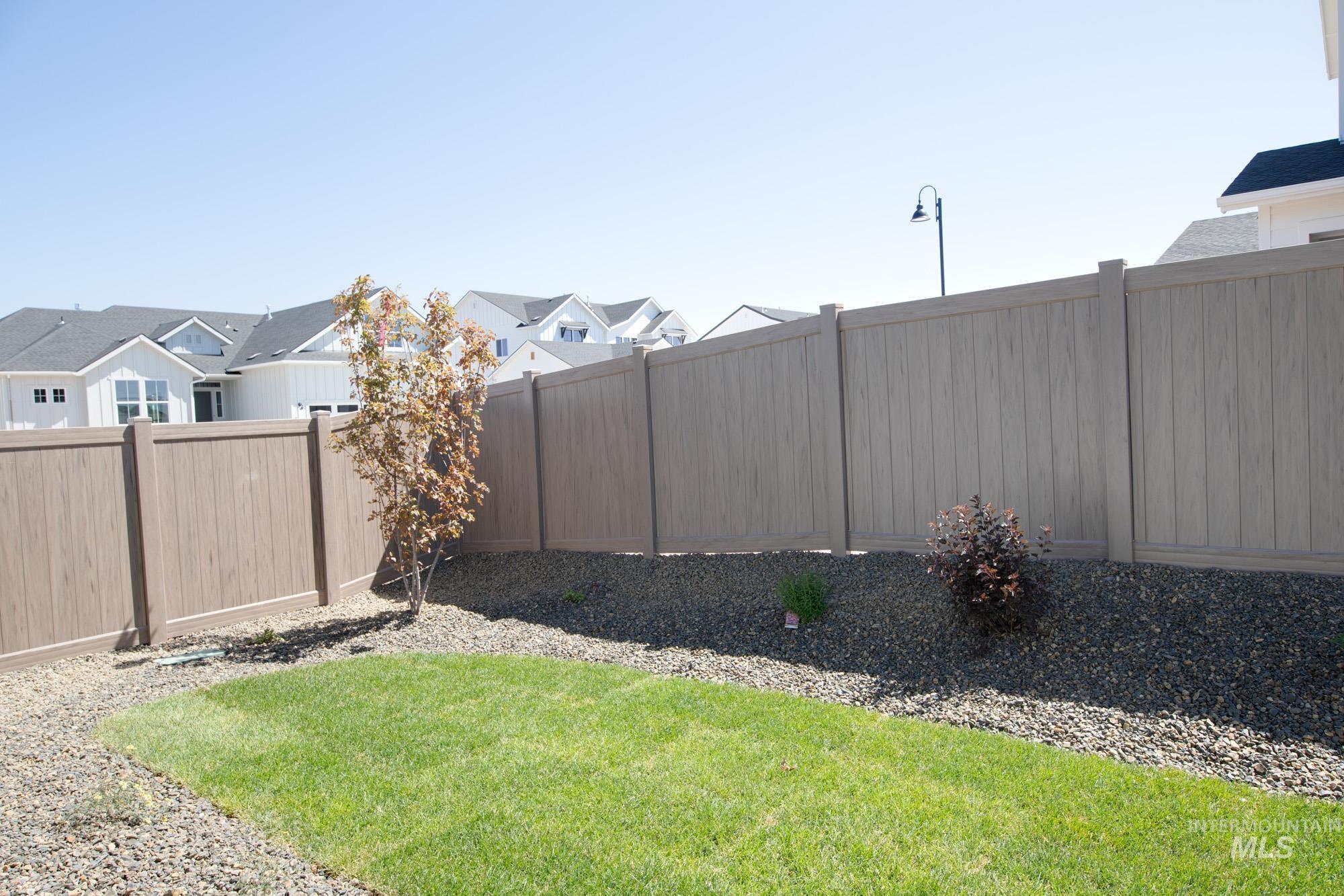 Fenced backyard featuring a residential view
