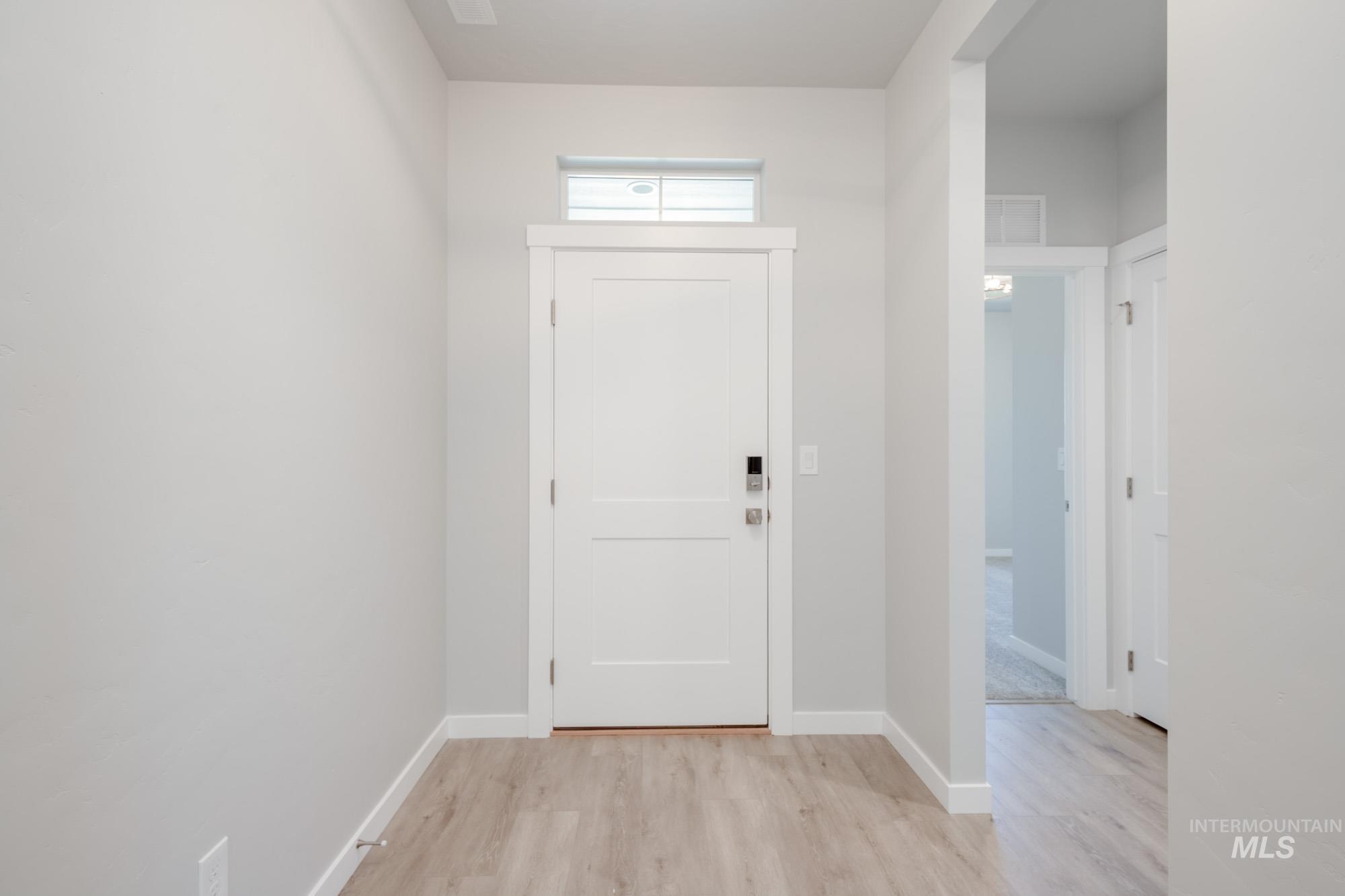 Foyer entrance featuring light wood-style flooring and baseboards