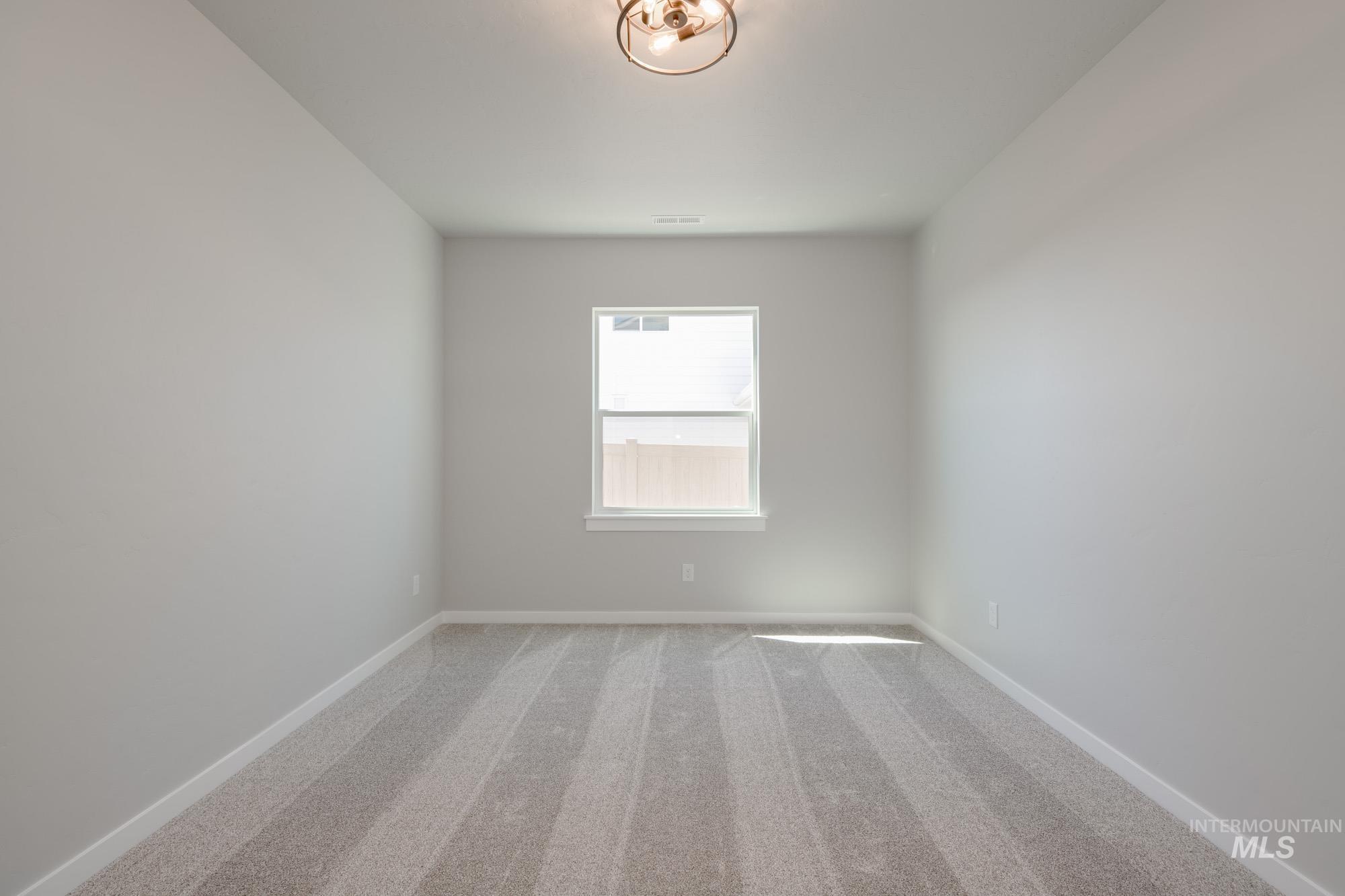 Spare room featuring baseboards and carpet floors