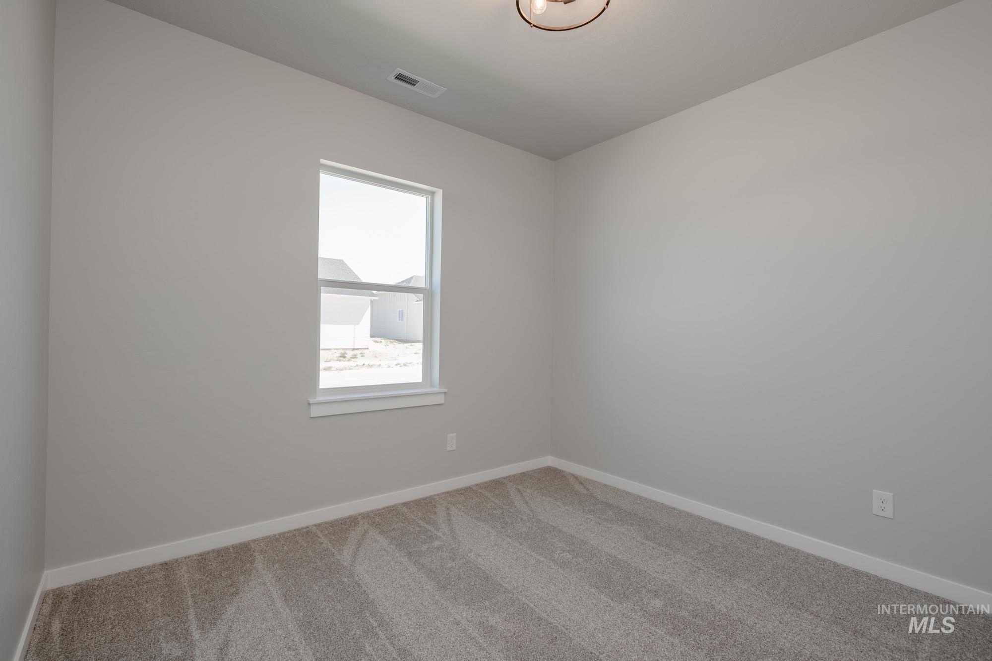 Carpeted spare room with baseboards
