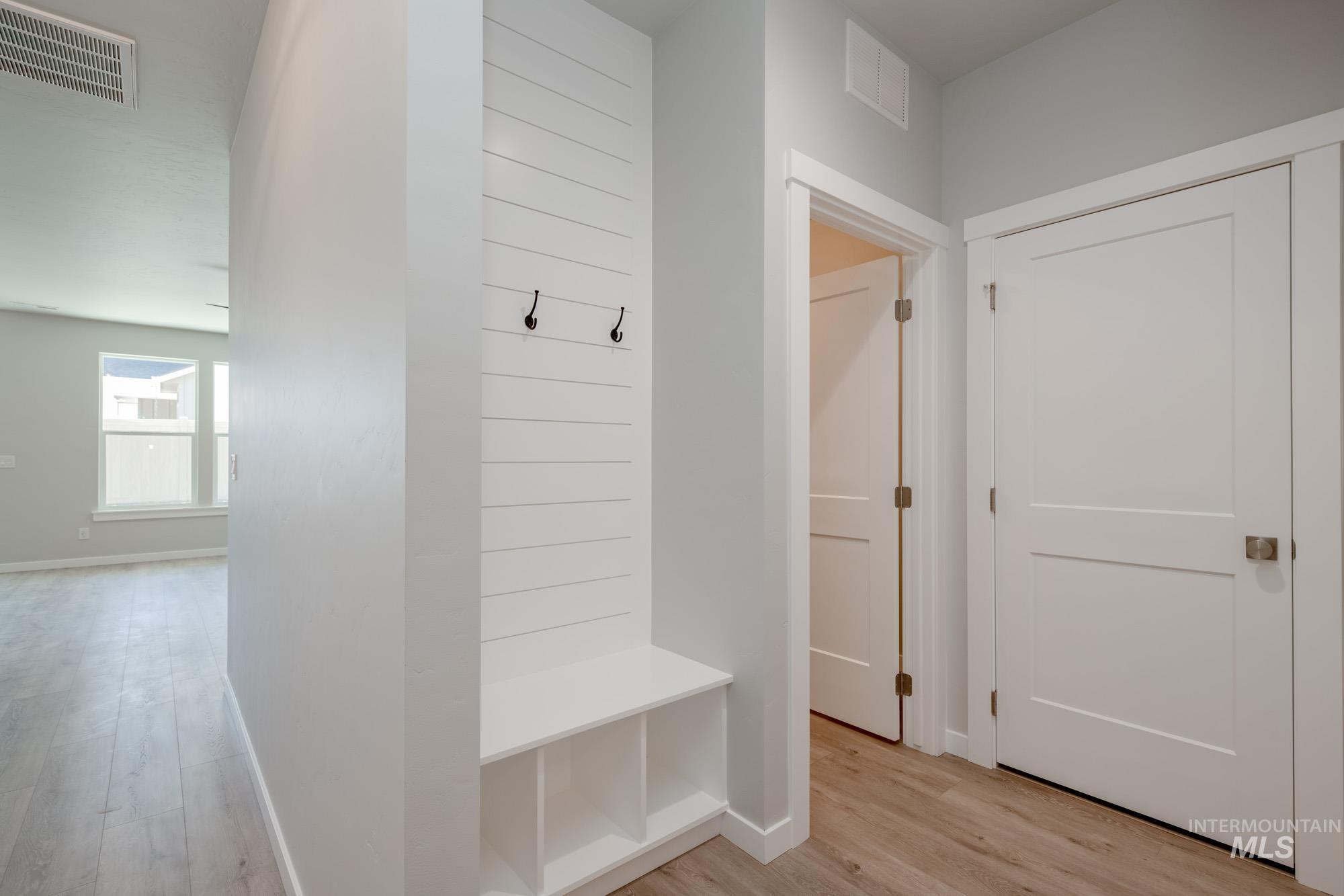 Mudroom with light wood finished floors and baseboards