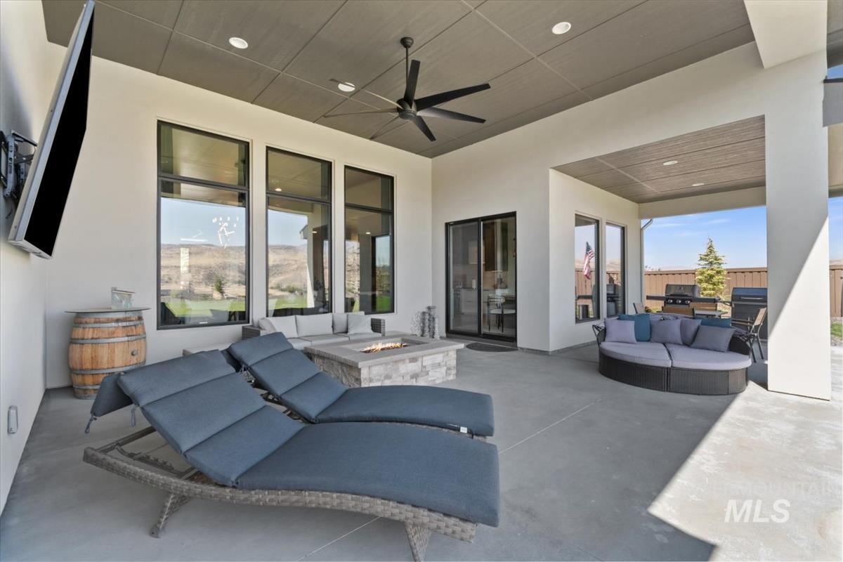 View of patio with an outdoor living space with a fire pit and a ceiling fan