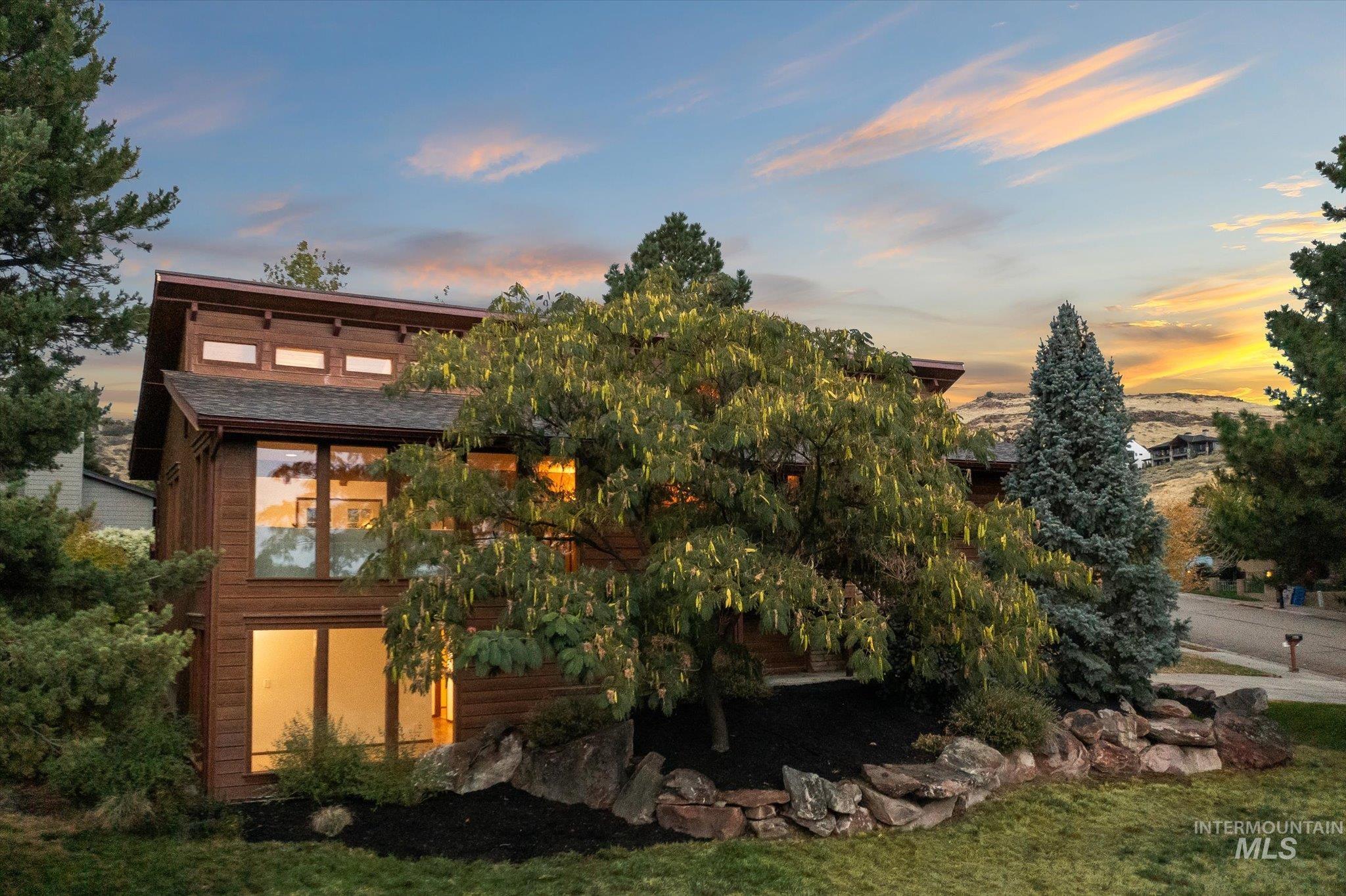 Back of house at dusk with a yard